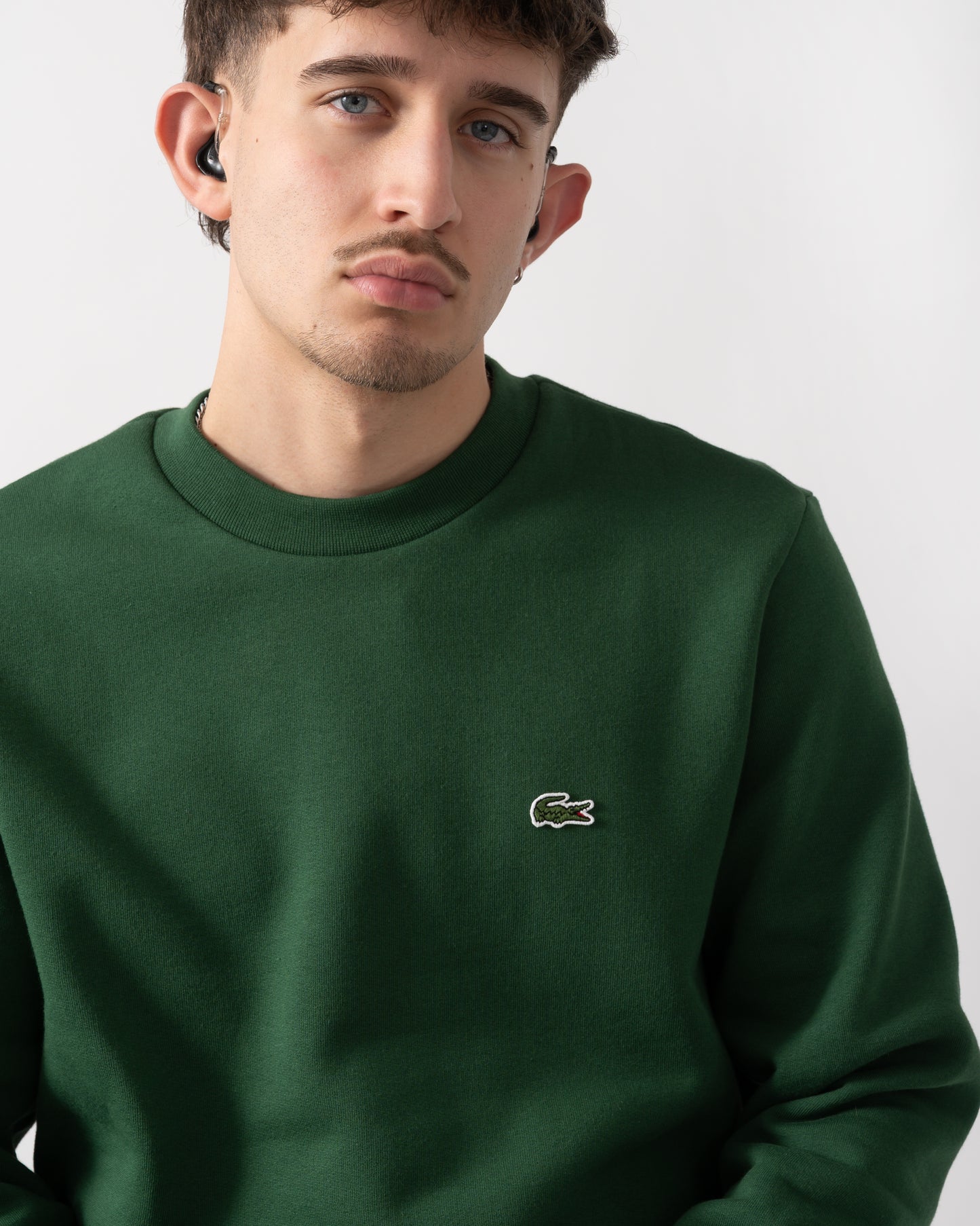 close up shot of a model wearing a Lacoste Mens Crew Neck Fleece Sweatshirt in Green 132