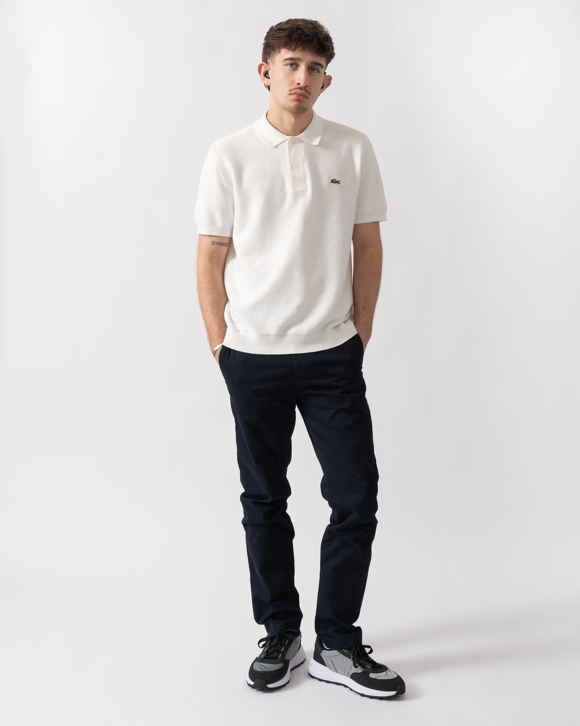 full length shot of a model wearing a Lacoste Moss Stitch Cotton Polo Collar Mens Sweater in Flour 70V
