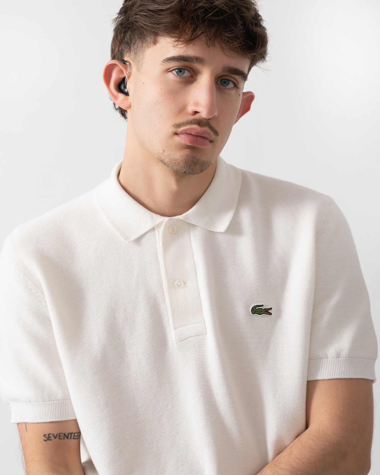 close up shot of a model wearing a Lacoste Moss Stitch Cotton Polo Collar Mens Sweater in Flour 70V
