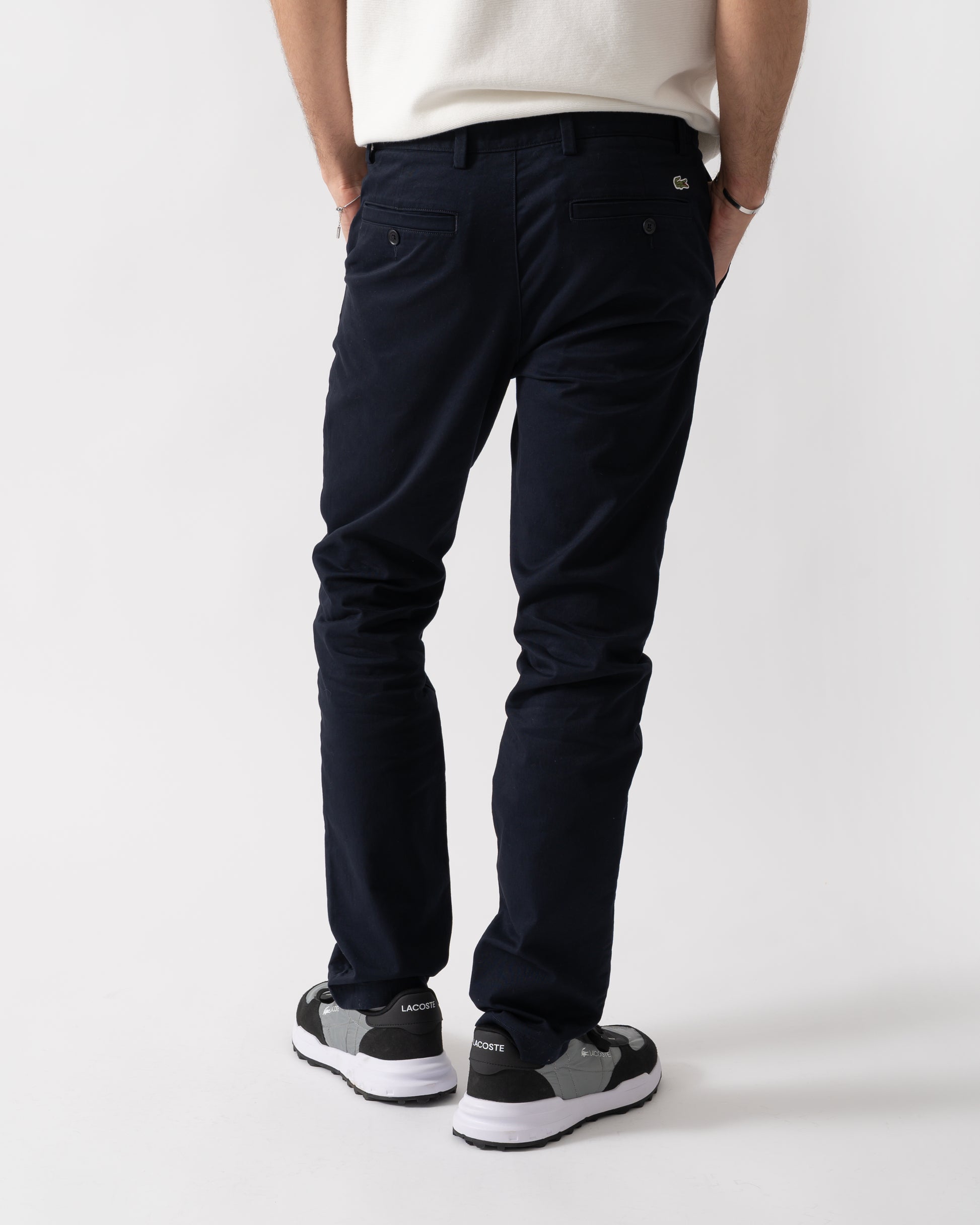 back shot of a model wearing Lacoste Slim Fit Stretch Cotton Mens Chinos in Abysm HDE