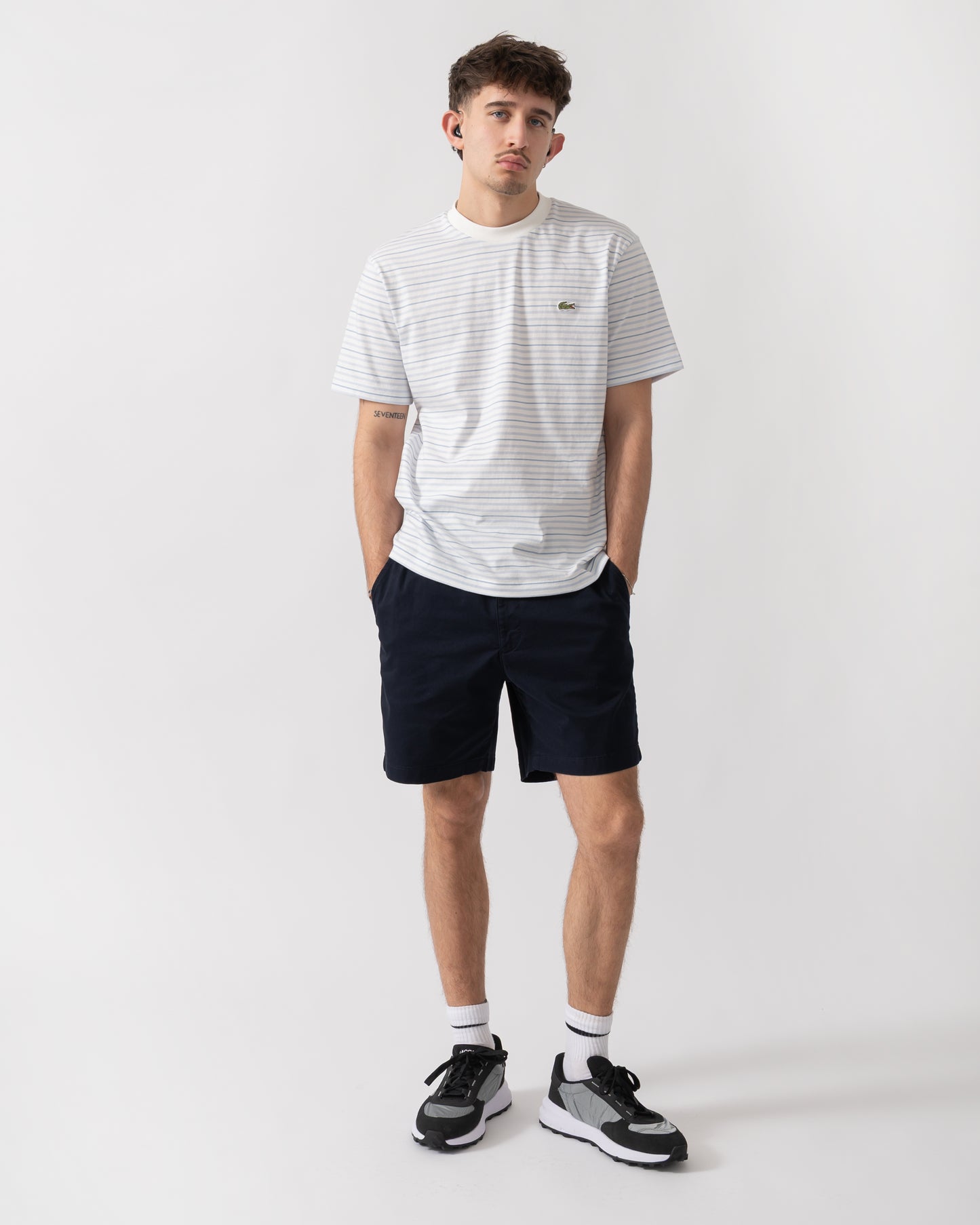 full length shot of a model wearing Lacoste Stripe Mens Classic Fit T-Shirt in Phoenix Blue-Flour