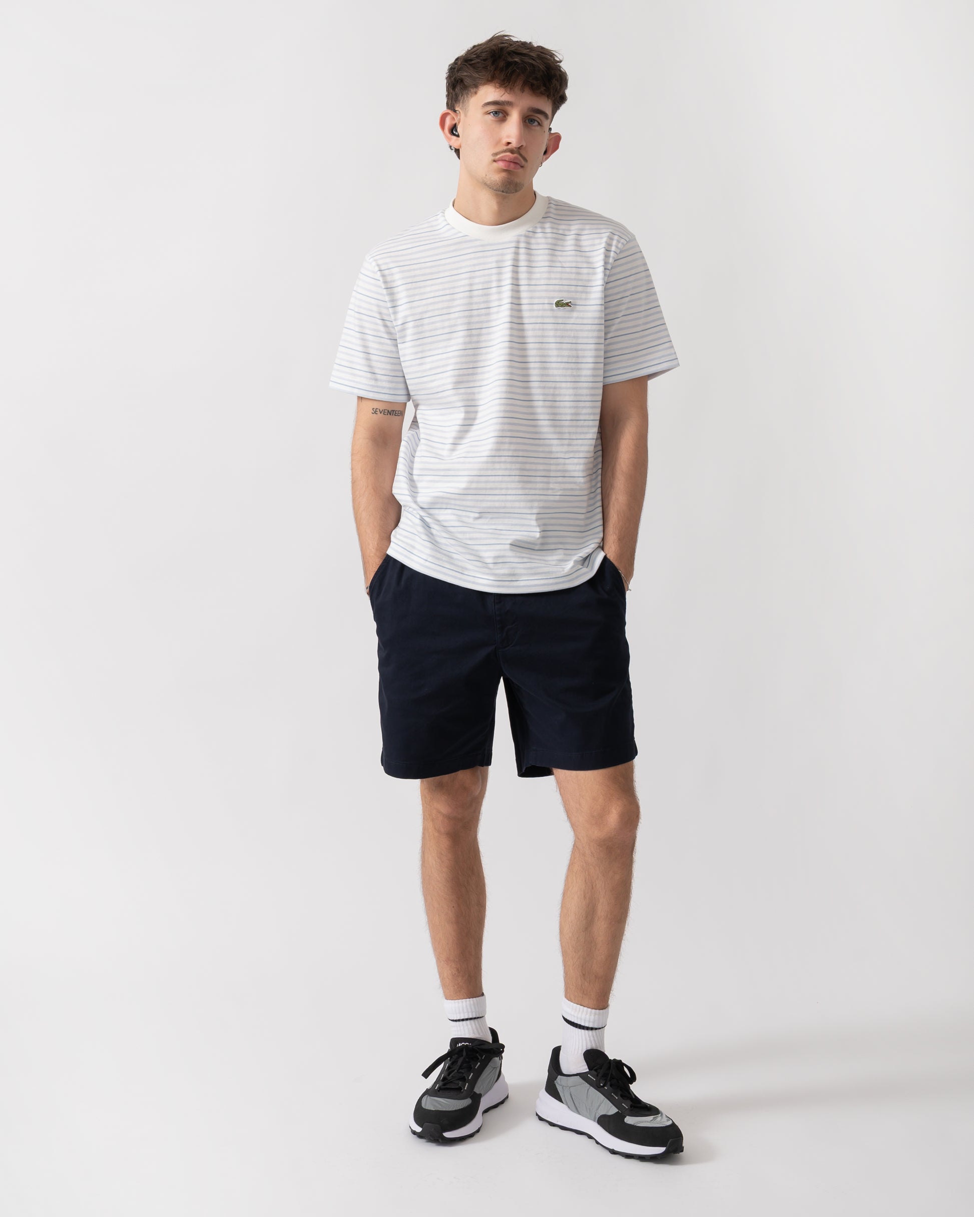 full length shot of a model wearing Lacoste Stripe Mens Classic Fit T-Shirt in Phoenix Blue-Flour