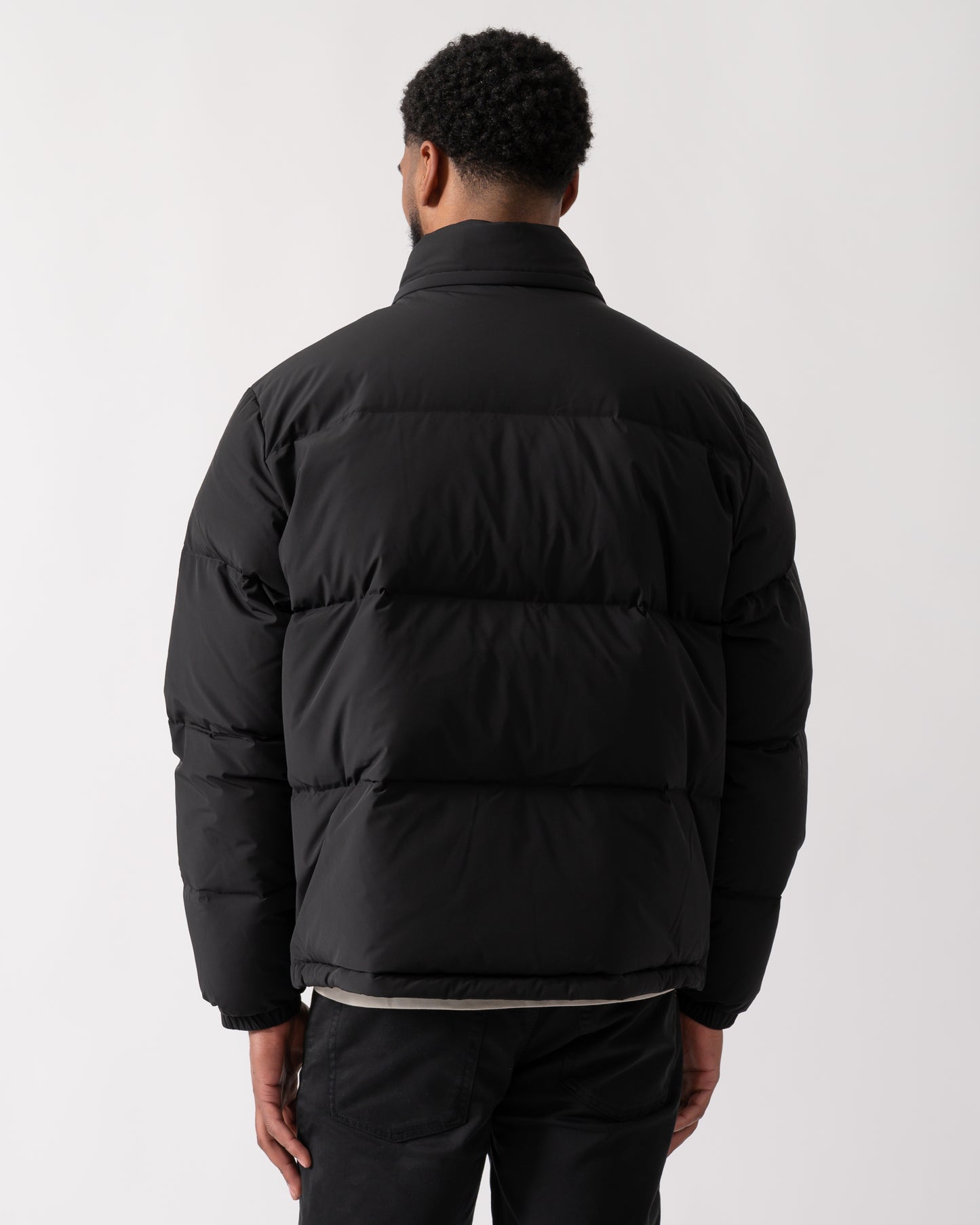 back shot of a model wearing a Lacoste Water-Repellent Packable Hood Mens Down Jacket in Black