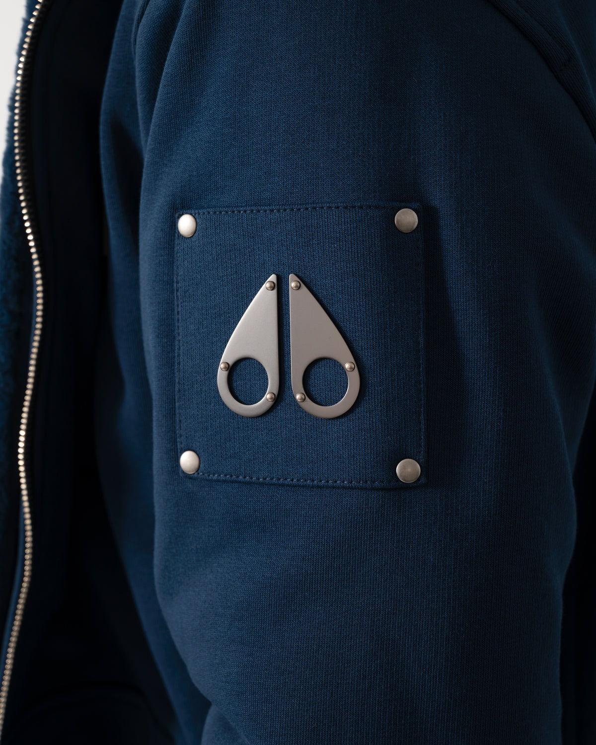 logo detail of a Moose Knuckles Classic Bunny 3 Mens Fleece Hoodie in Nightfall 2017 