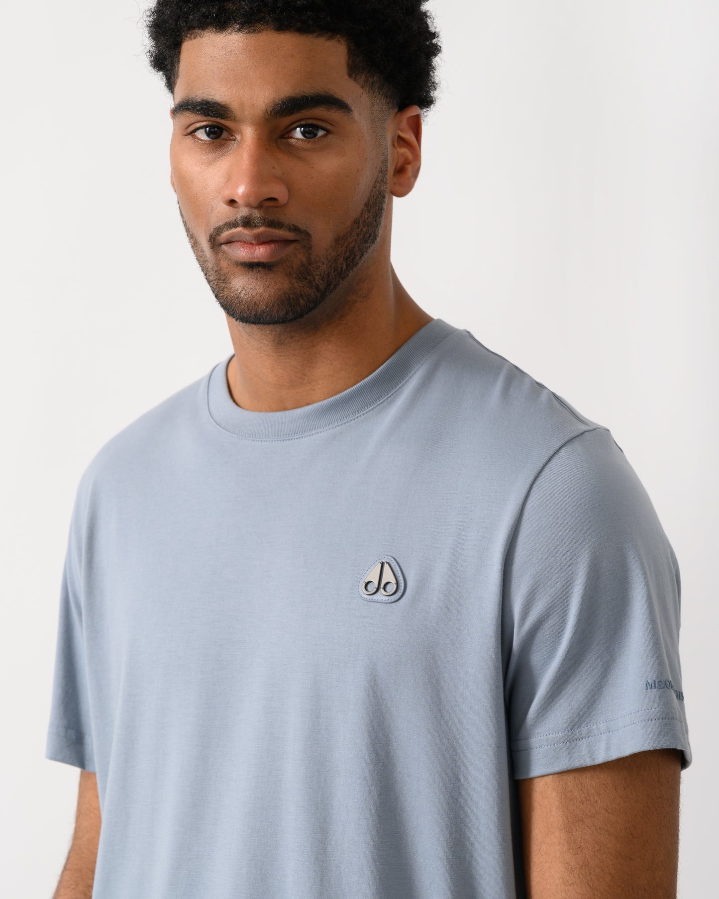 close up shot of a model wearing a Moose Knuckles Crescent Mens T-Shirt in Jet Stream 1884