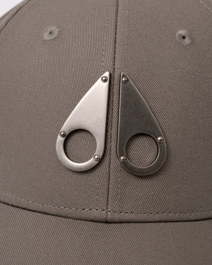 logo detail of a Moose Knuckles Front Logo Icon Cap in Ashen 1968
