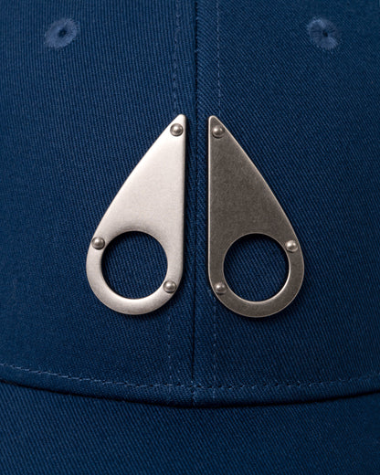 logo detail of a Moose Knuckles Front Logo Icon Cap in Nightfall 1977