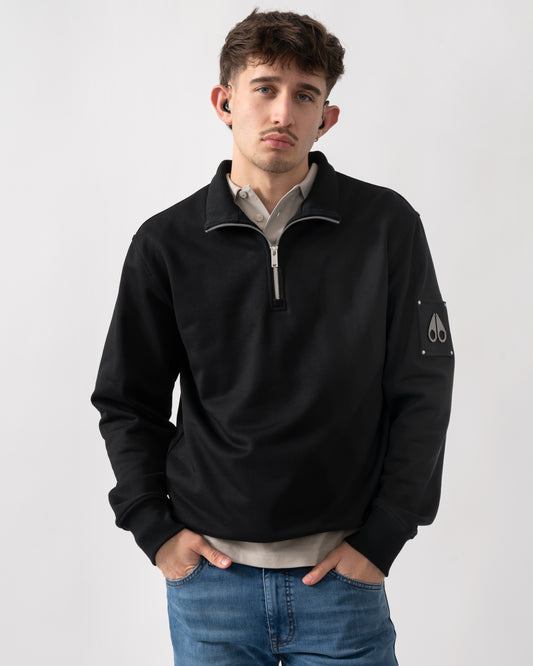 Studio shot of a model wearing a Moose Knuckles Hartsfield Mens quarter Zip Sweatshirt in Black 292