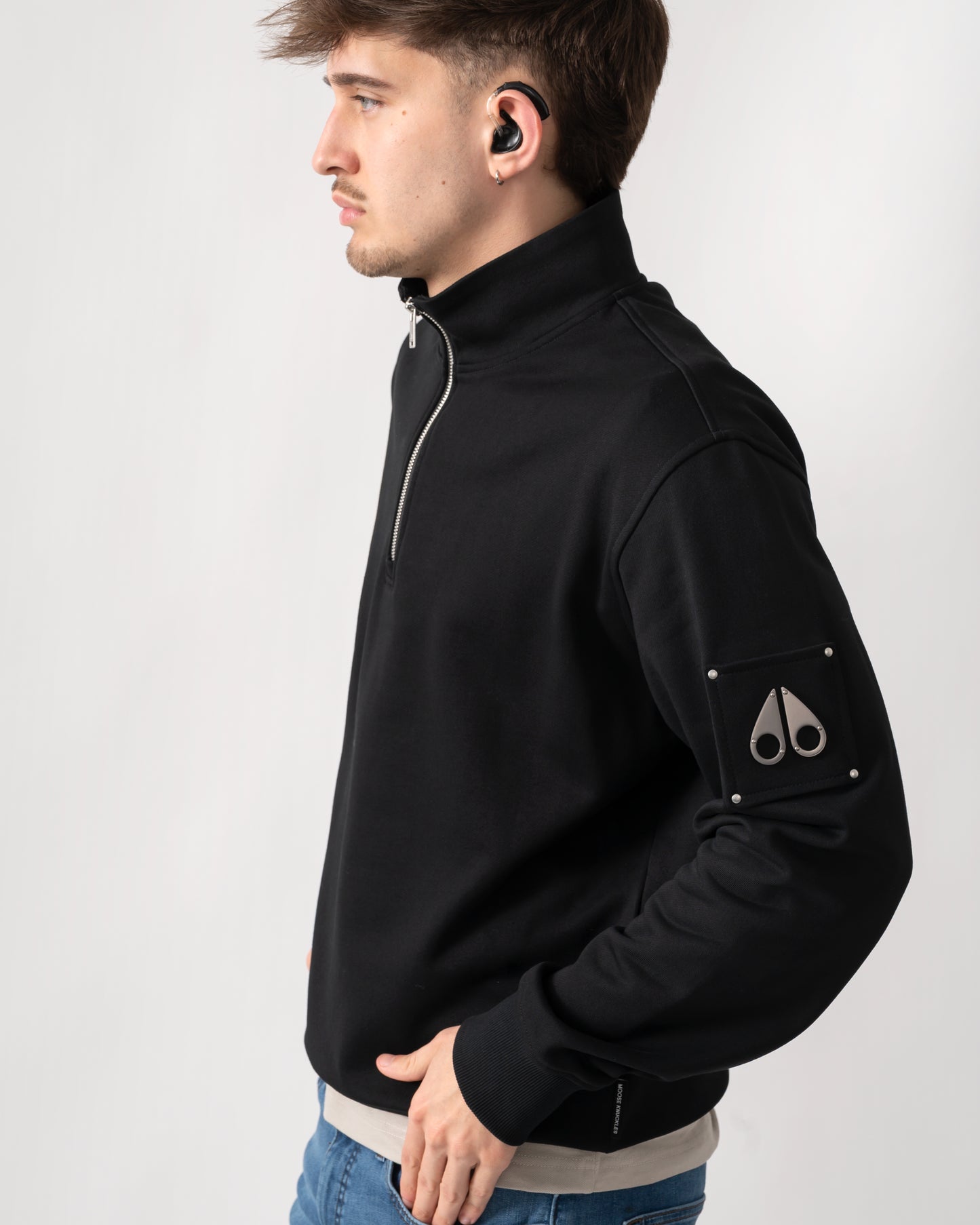 side shot of a model wearing a Moose Knuckles Hartsfield Mens quarter Zip Sweatshirt in Black 292