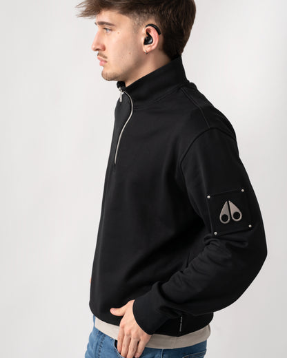 side shot of a model wearing a Moose Knuckles Hartsfield Mens quarter Zip Sweatshirt in Black 292