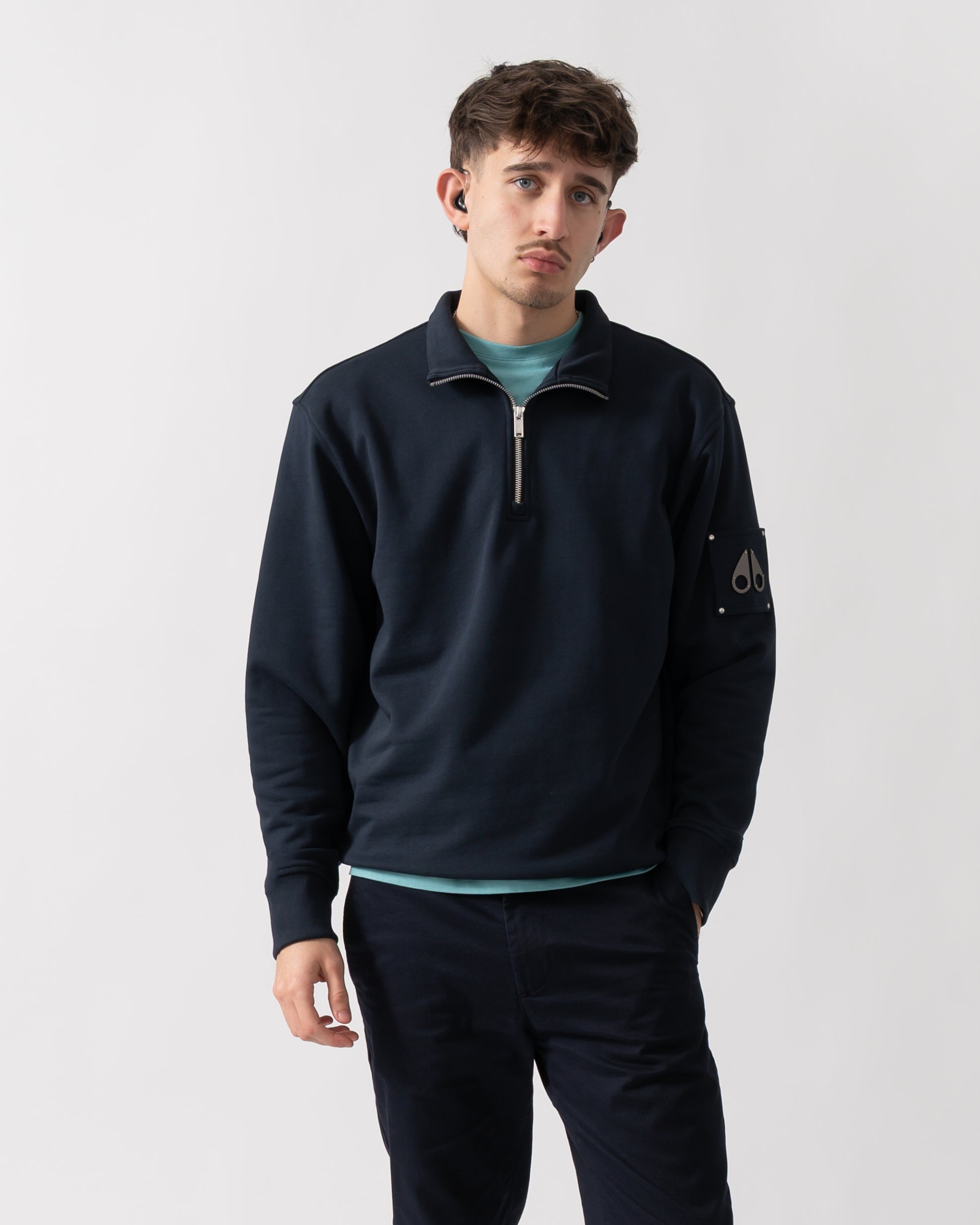 studio shot of a model wearing a Moose Knuckles Hartsfield Mens quarter Zip Sweatshirt in Navy 833