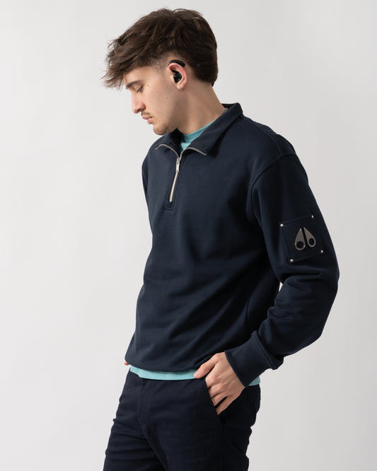 side shot of a model wearing a Moose Knuckles Hartsfield Mens quarter Zip Sweatshirt in Navy 833