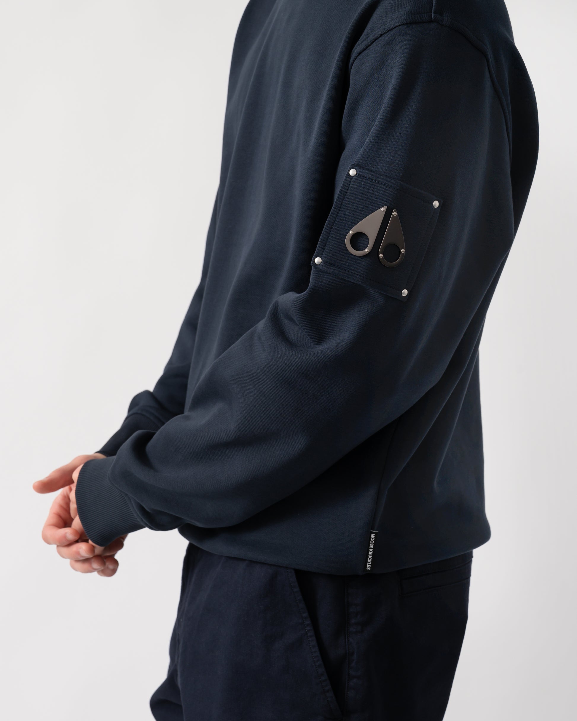 detail shot of a model wearing a Moose Knuckles Hartsfield Mens Crew Neck Sweatshirt in Navy 833