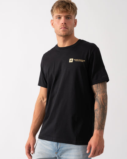 Model wearing a Moose Knuckles Keshi Gold Mens T-Shirt in Black