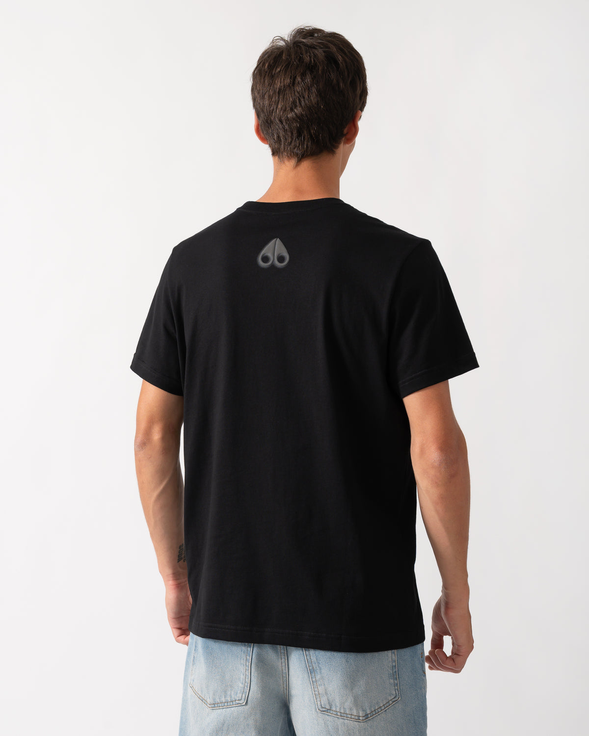 back of a model wearing a Moose Knuckles Mens Shadow Logo T-Shirt in Black 292