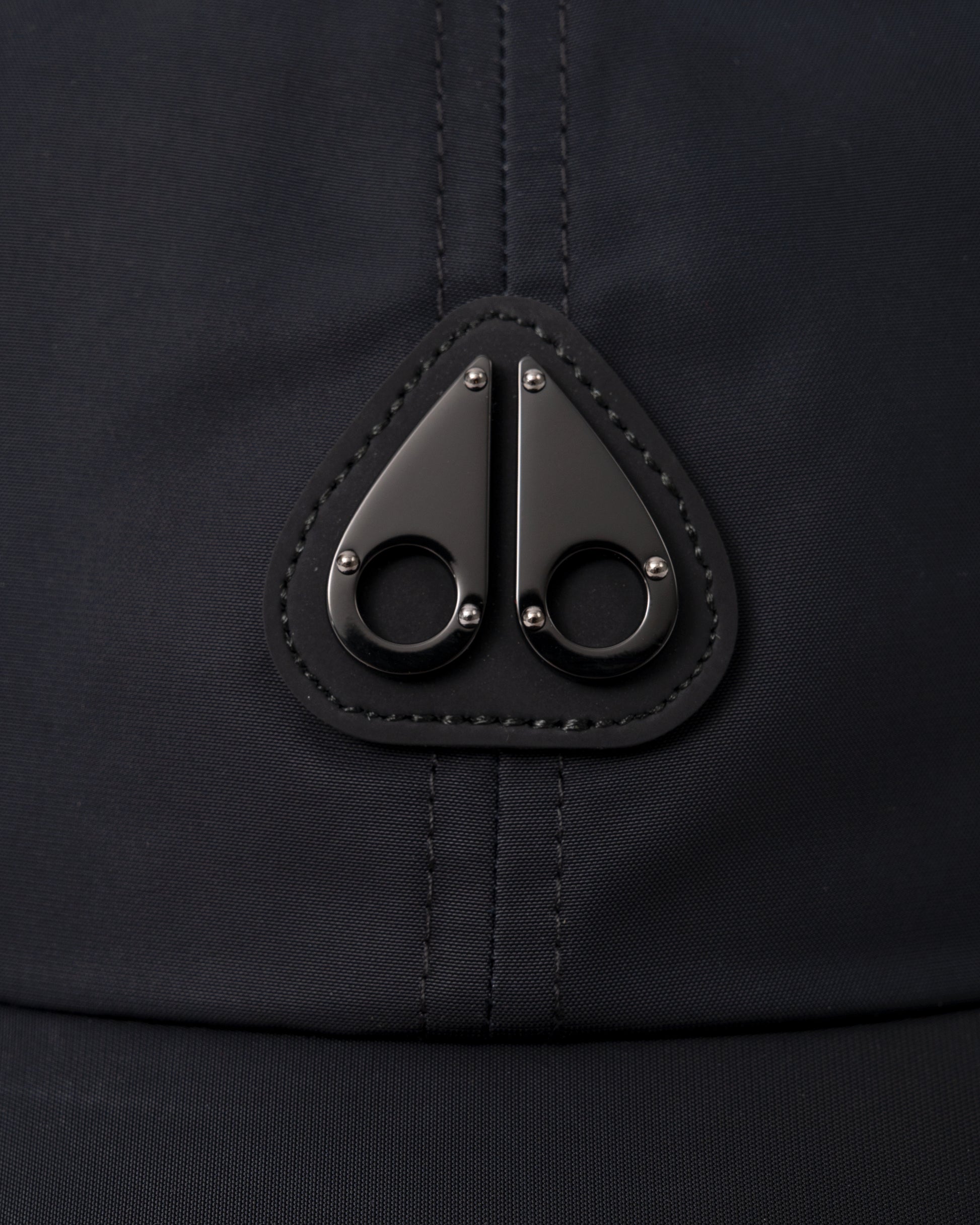 logo detail of a Moose Knuckles Mens Vick Cap in Black 292