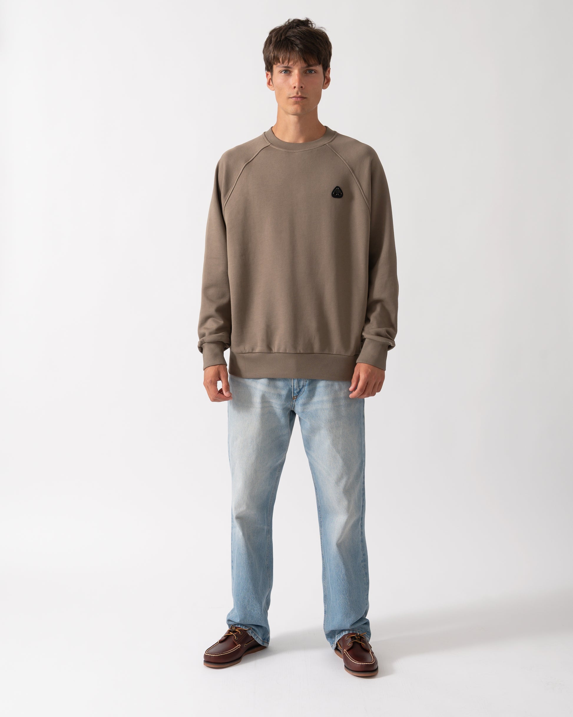 full length shot of a model wearing a Moose Knuckles Mens Yul Crewneck Sweatshirt in Ashen 1968