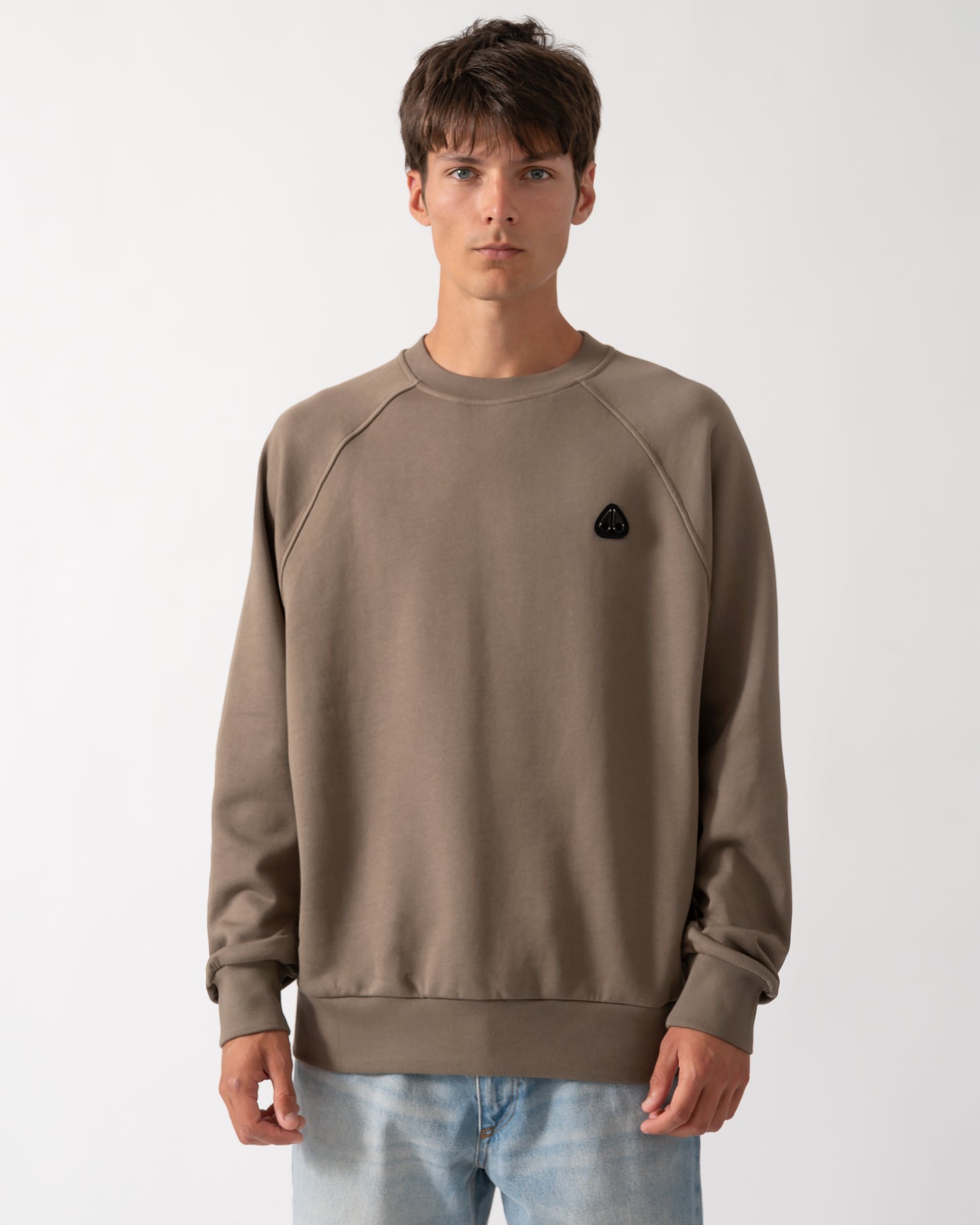 model wearing a Moose Knuckles Mens Yul Crewneck Sweatshirt in Ashen 1968