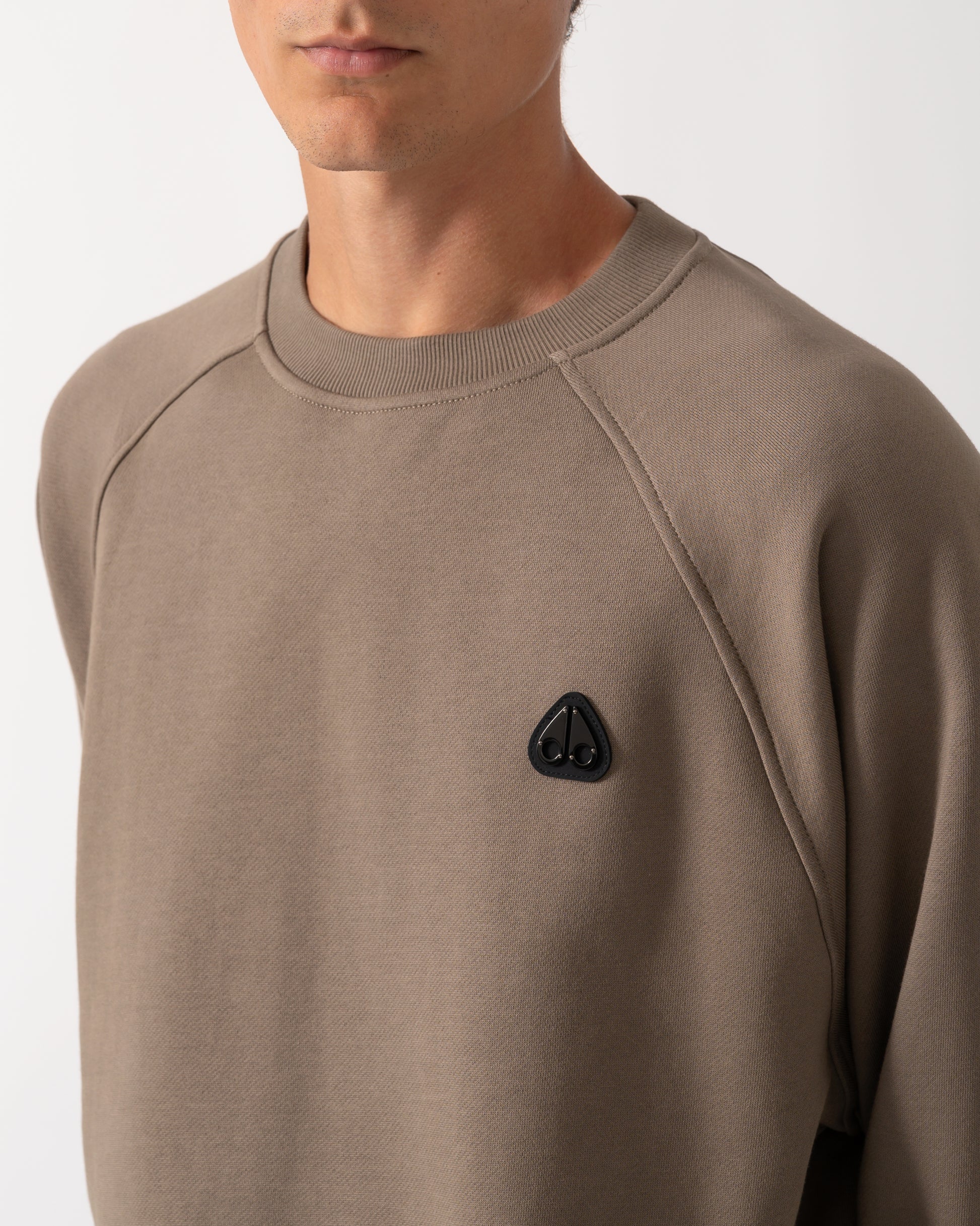 close up model wearing a Moose Knuckles Mens Yul Crewneck Sweatshirt in Ashen 1968