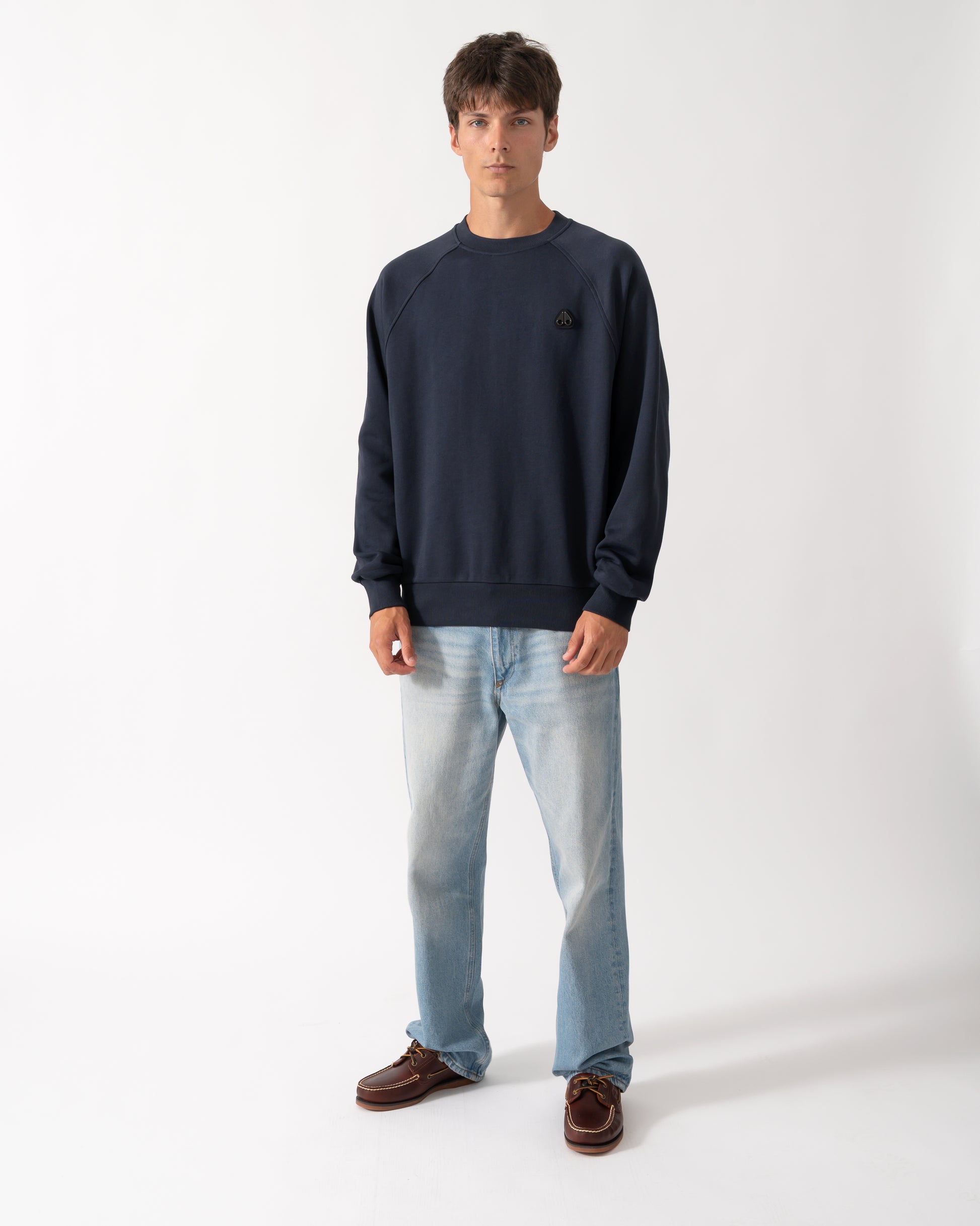 full length of a model wearing a Moose Knuckles Mens Yul Crewneck Sweatshirt in Navy 833