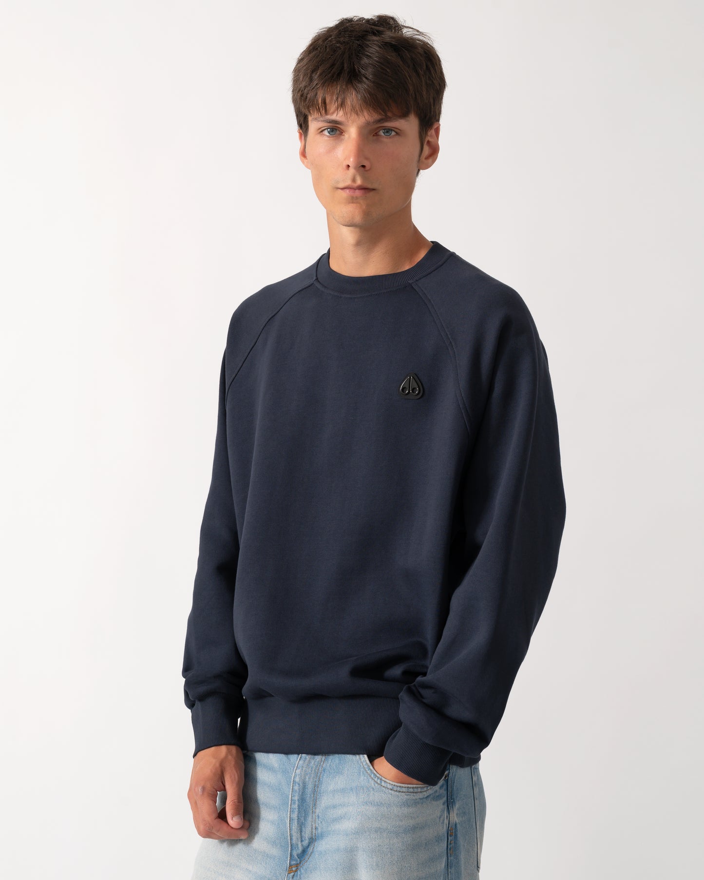 model wearing a Moose Knuckles Mens Yul Crewneck Sweatshirt in Navy 833