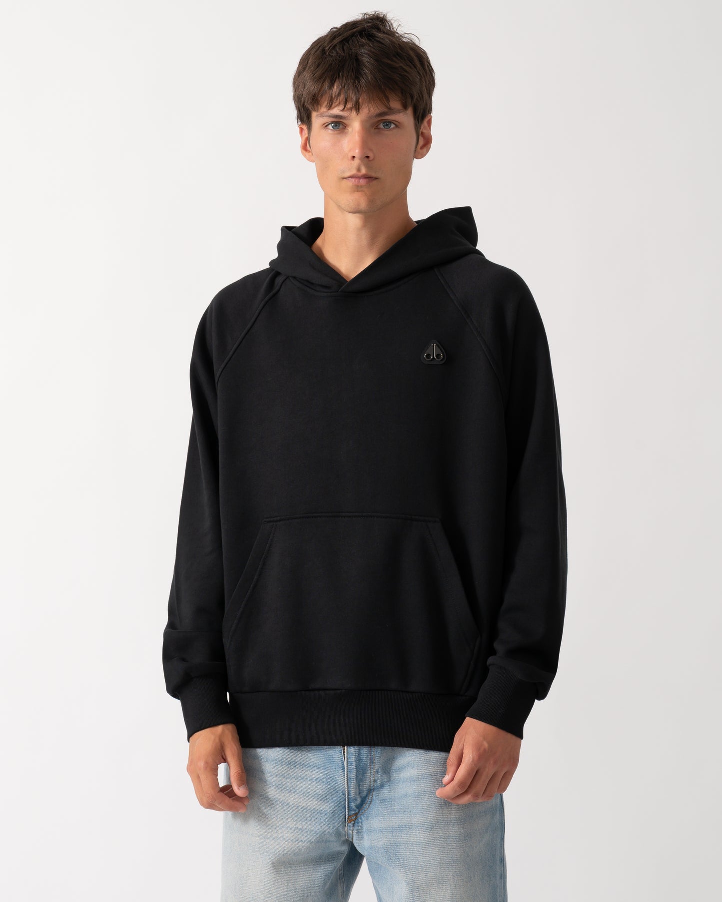 a model wearing a Moose Knuckles Mens Yul Pullover Hoodie in Black 292
