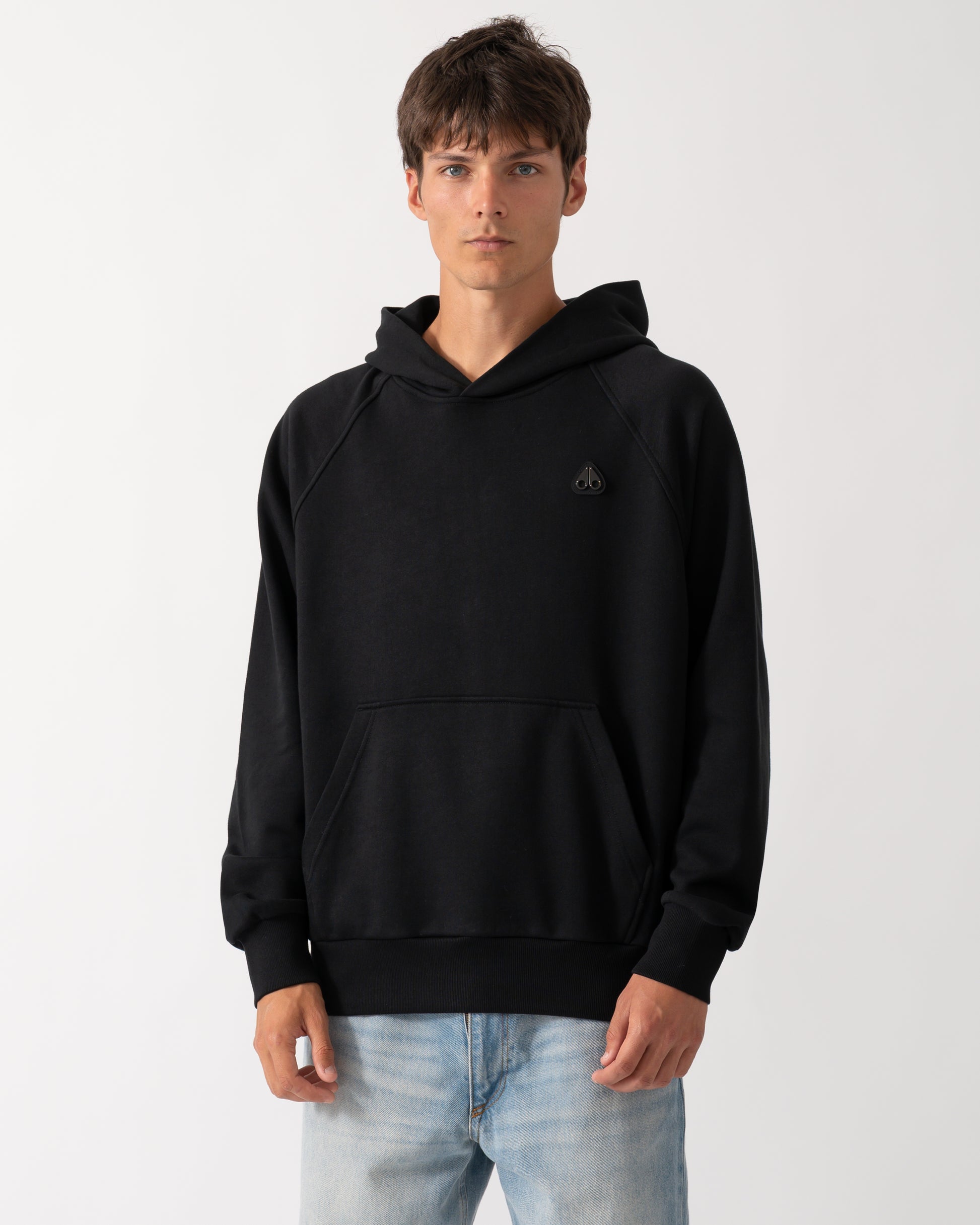 a model wearing a Moose Knuckles Mens Yul Pullover Hoodie in Black 292