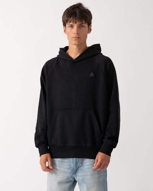 a model wearing a Moose Knuckles Mens Yul Pullover Hoodie in Black 292