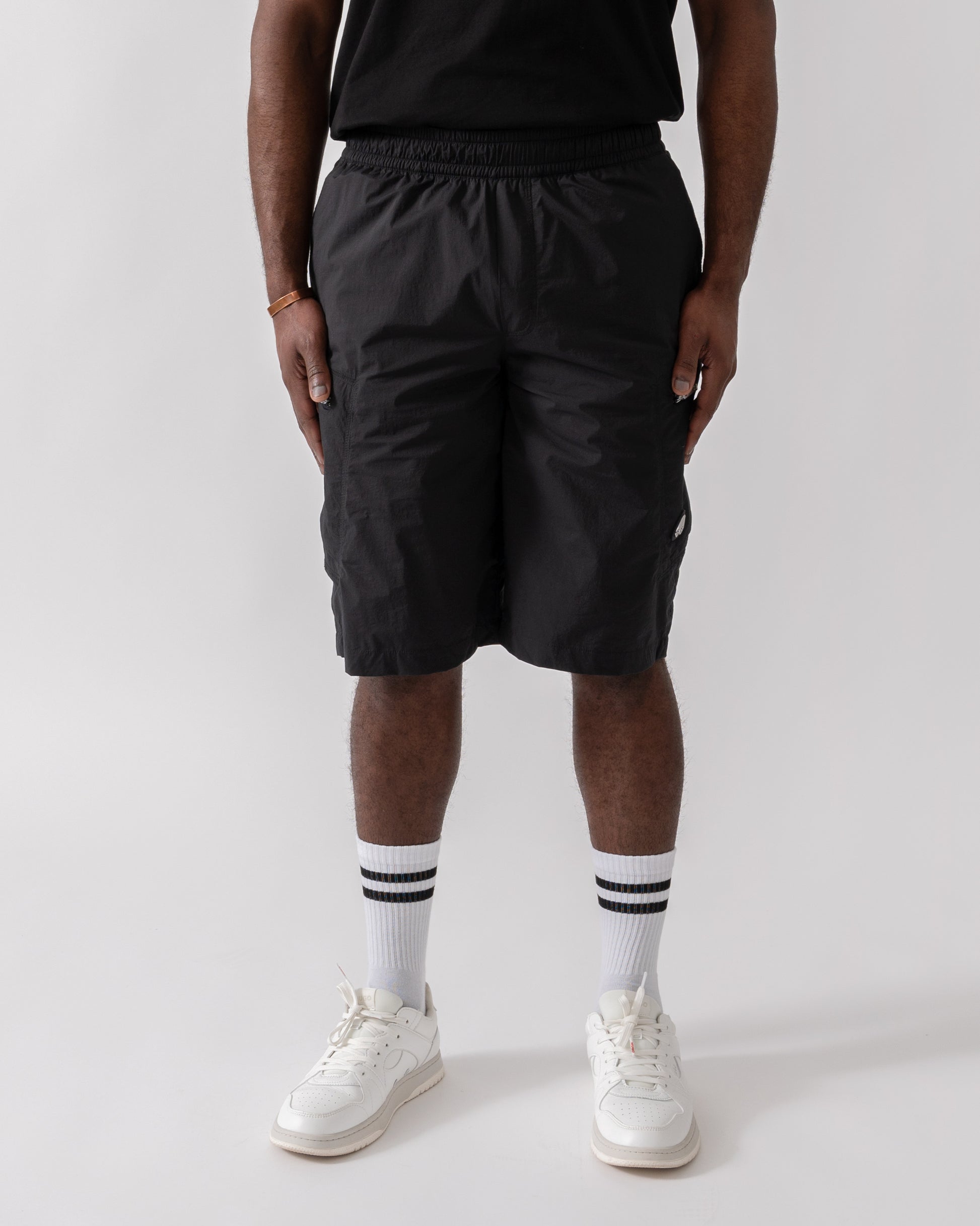Model wearing Moose Knuckles Topflight Mens Cargo Shorts in Black 292 - front