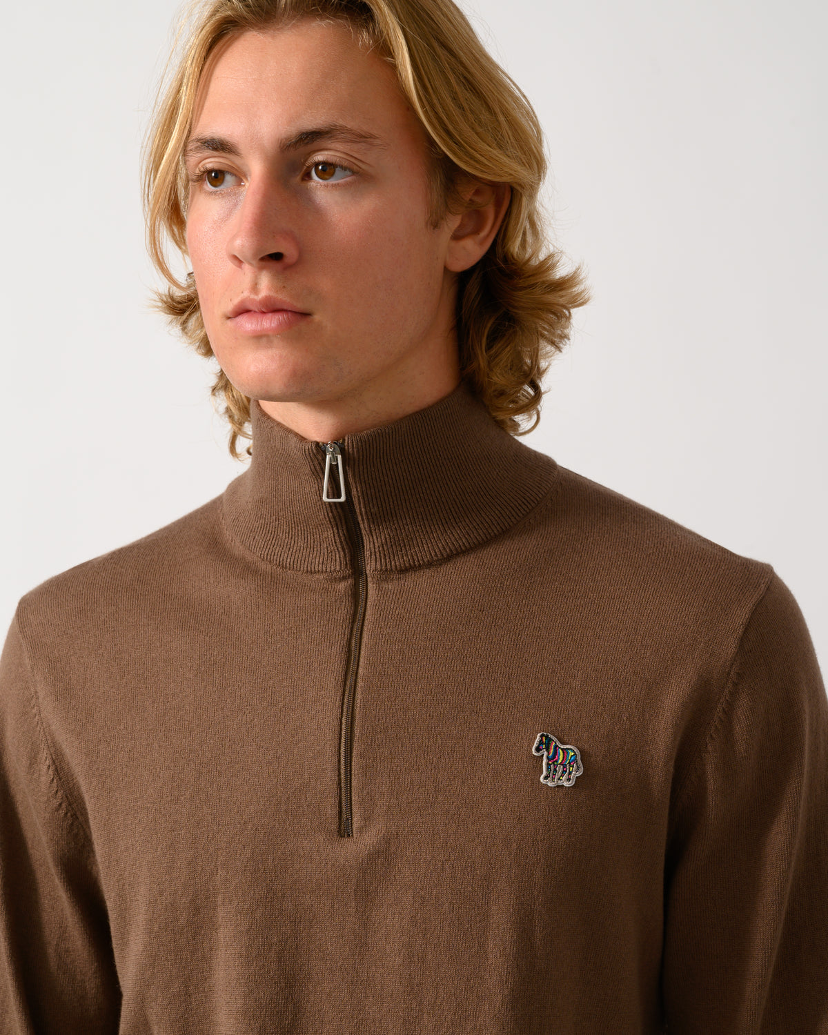 close up of model wearing a PS Paul Smith Mens 1/4 Zip Zebra Badge Sweater in 67 Mud