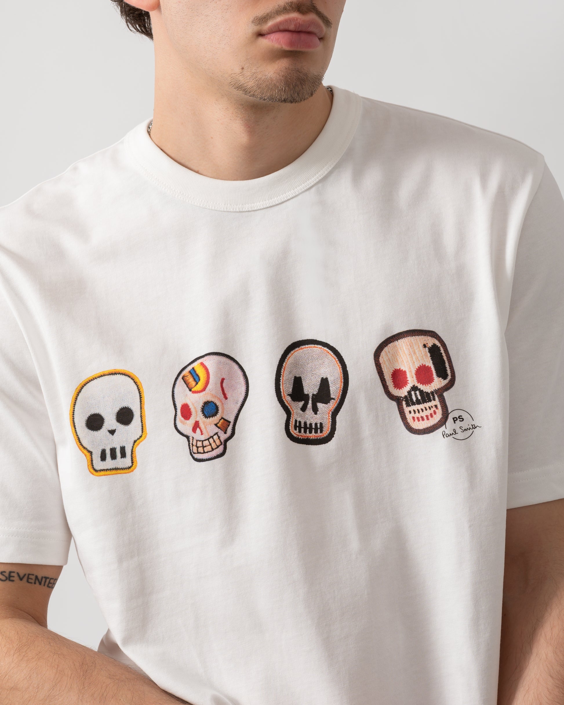 close up shot of a model wearing a PS Paul Smith Mens Casual Fit Skulls T-Shirt in 02 White