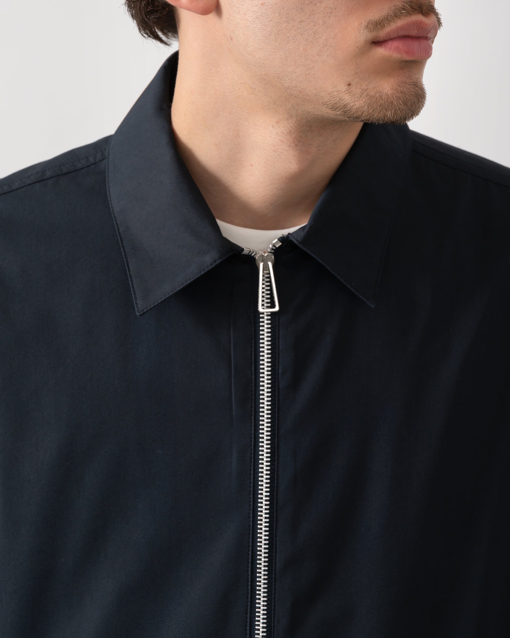 close up shot of a model wearing a PS Paul Smith Mens Coach Jacket in 49 Very Dark Navy