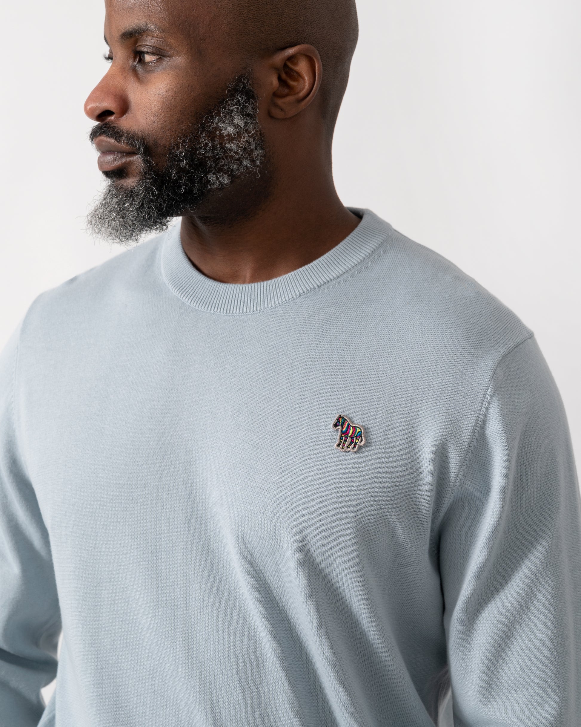 Detail shot of a Model wearing a PS Paul Smith Mens Crew Neck Zebra Badge Jumper in Blue