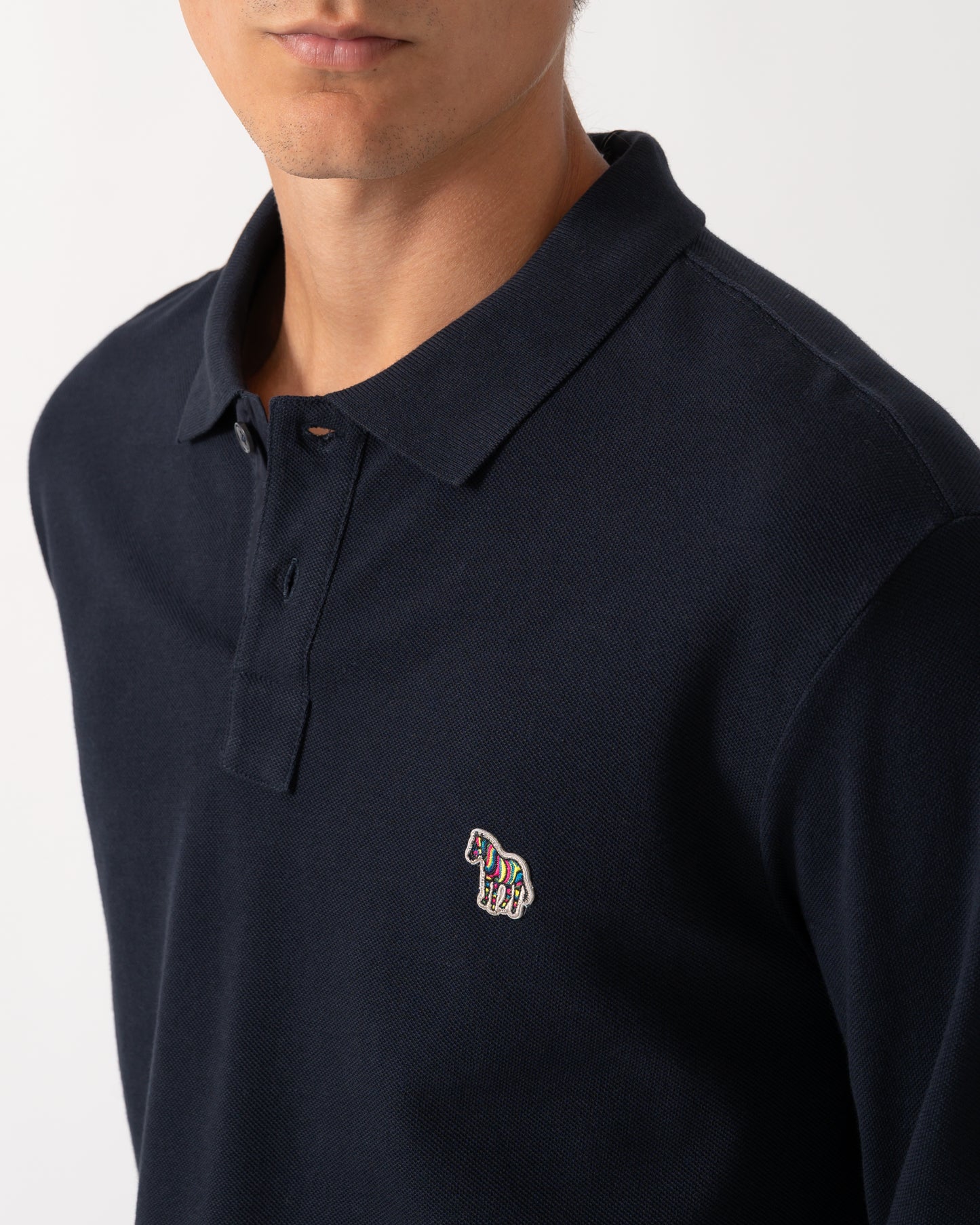 close up of a model wearing a PS Paul Smith Mens Long Sleeve Plain Polo Shirt with Zebra Logo in 49 Very Dark Navy