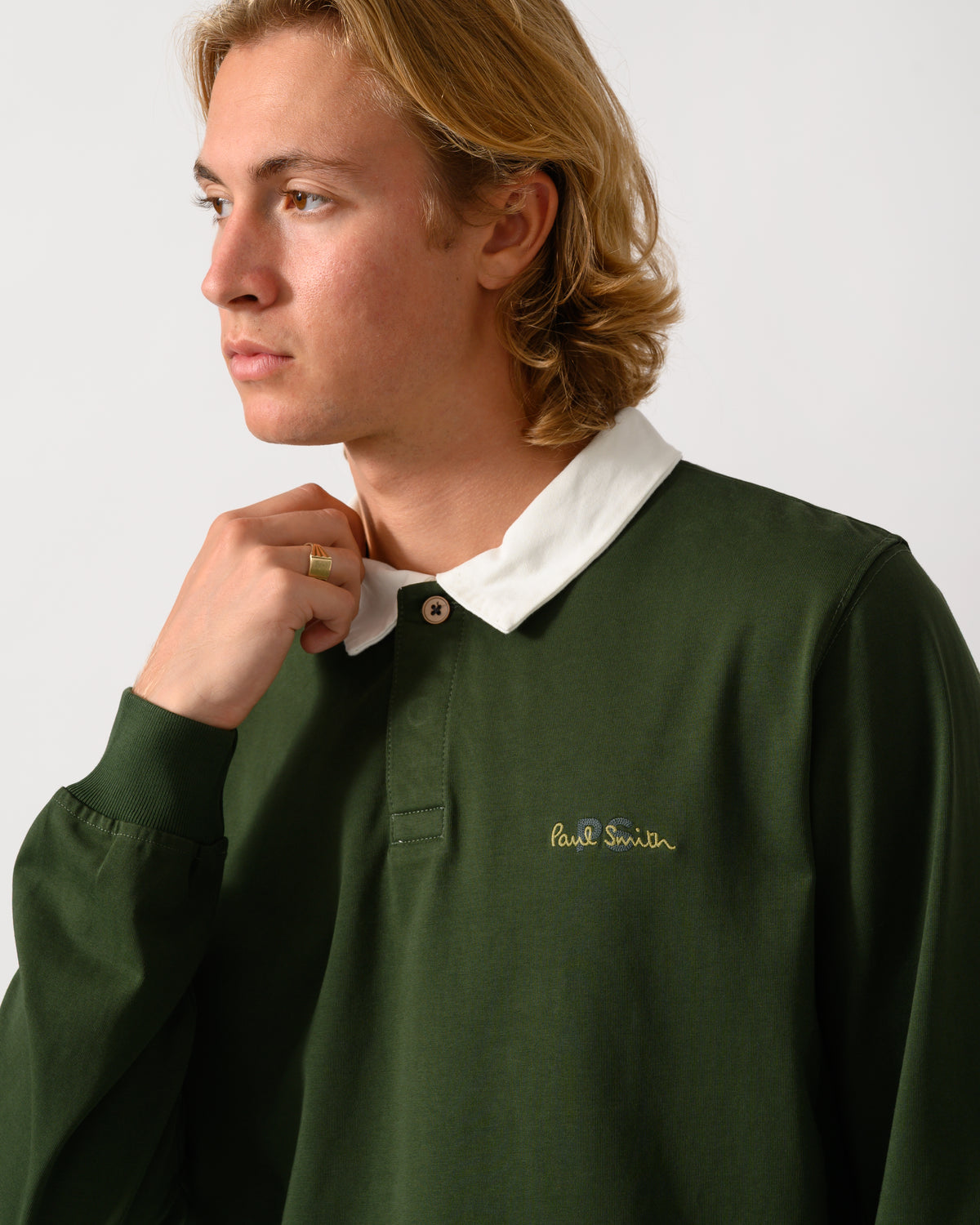 close up studio photograph of a model wearing a PS Paul Smith Mens Long Sleeve Signature Logo Polo in 38A Bottle Green