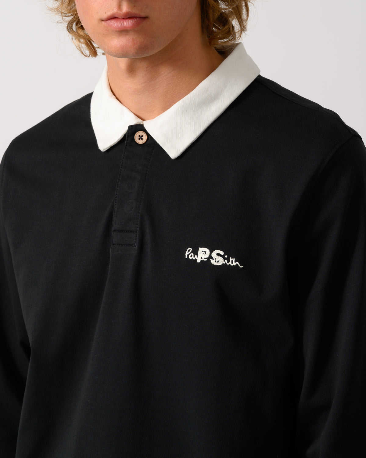 close up studio photograph of a model wearing a PS Paul Smith Mens Long Sleeve Signature Logo Polo a 79 Black