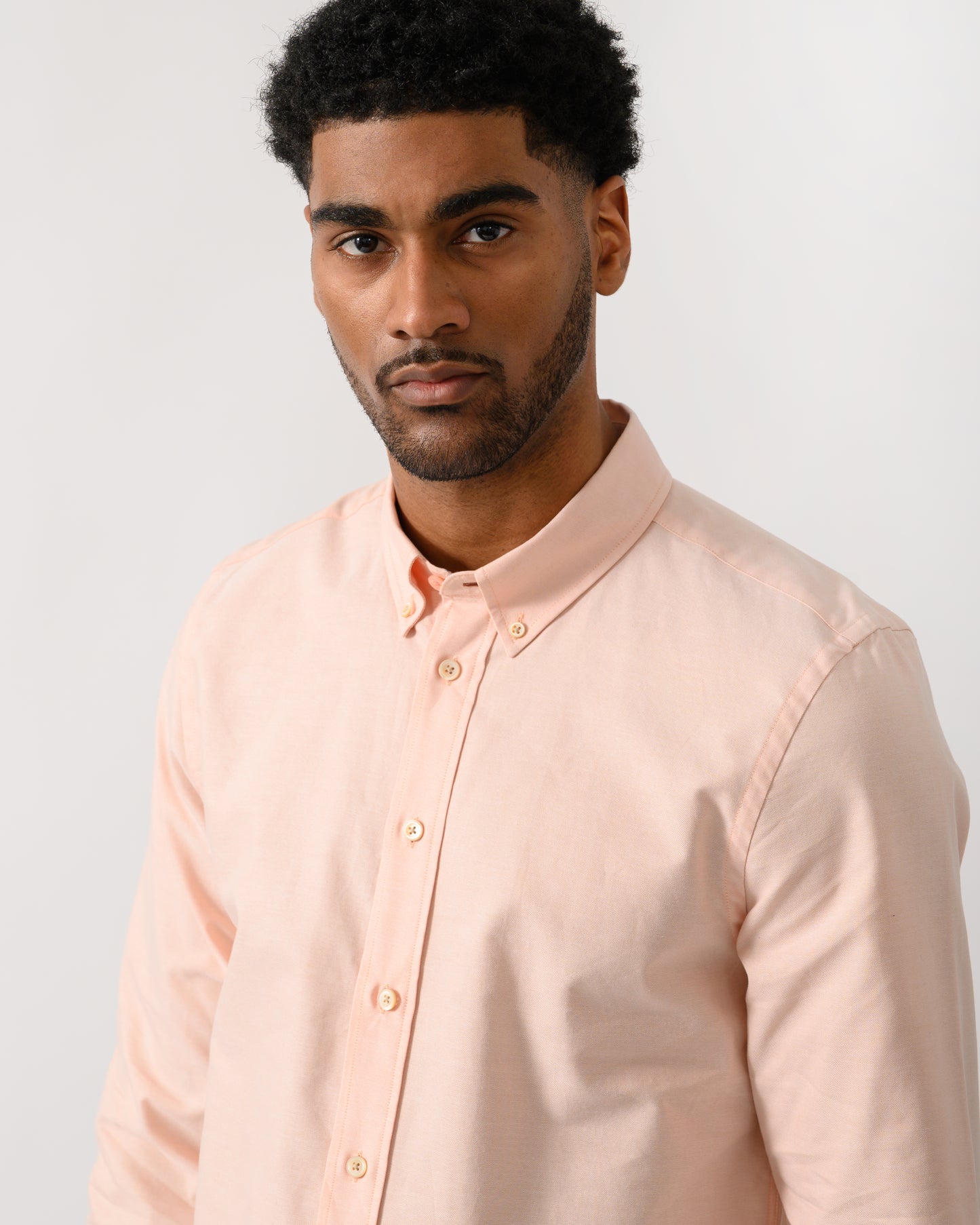 close up shot of a model wearing a PS Paul Smith Mens Long Sleeve Tailored Fit Shirt With Button Down Collar in Orange