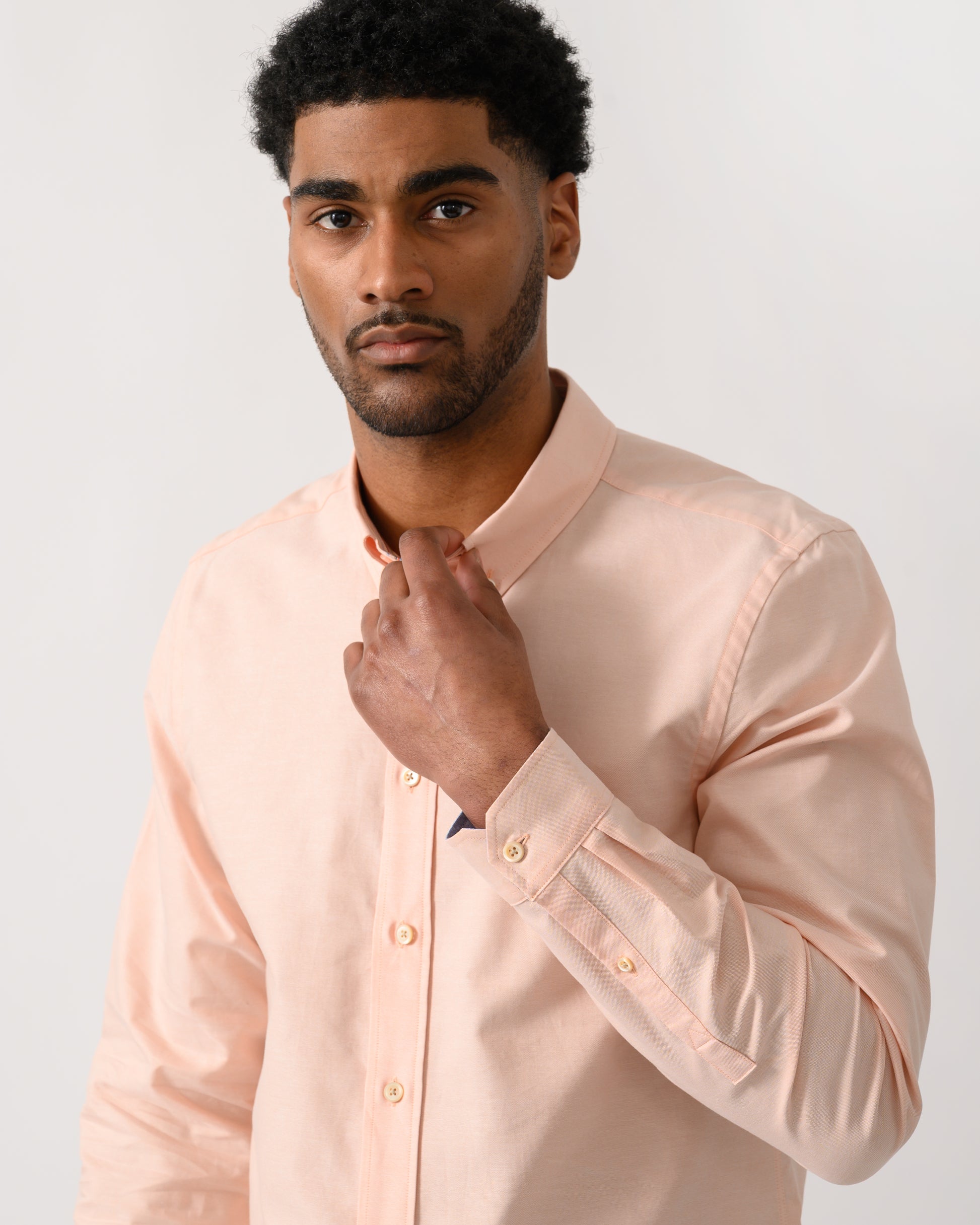 close up shot of a model wearing a PS Paul Smith Mens Long Sleeve Tailored Fit Shirt With Button Down Collar in Orange