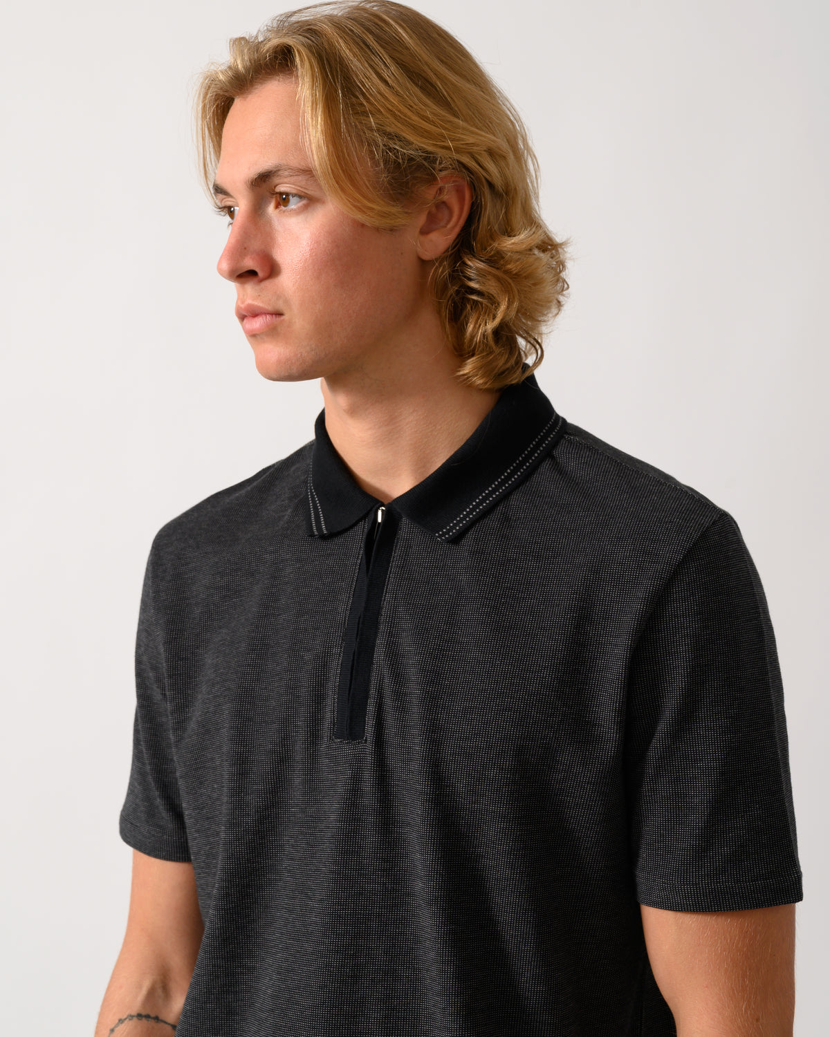 close up studio photograph of a model wearing a PS Paul Smith Mens Reg Fit Zip Polo Shirt in 79 Black