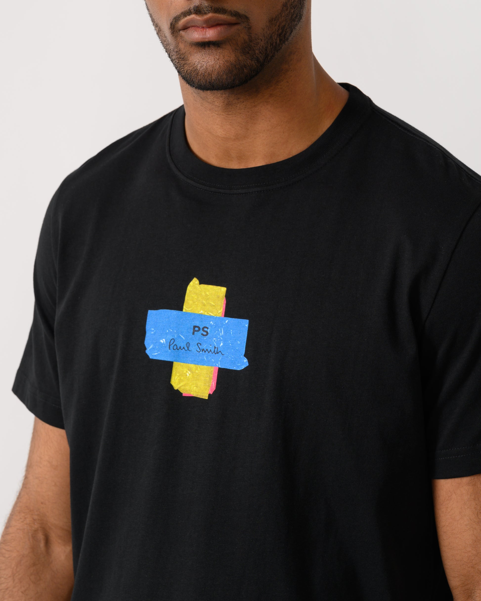 close up of a model wearing a PS Paul Smith Mens Regular Fit Cross T-Shirt in 79 Black