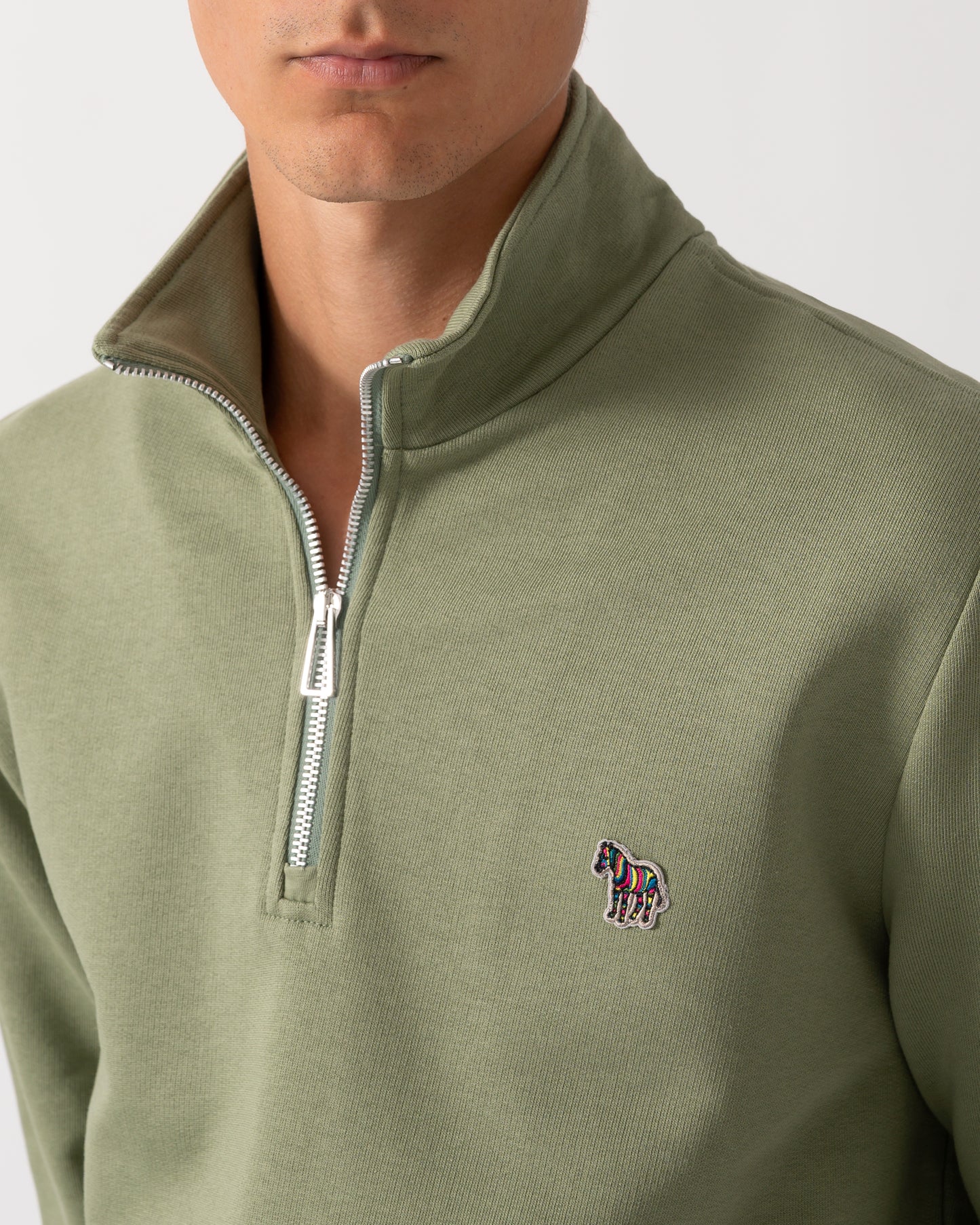 close up of a model wearing a PS Paul Smith Mens Regular Fit Half Zip Sweatshirt with Zebra Logo in 34C Light Greyish Green