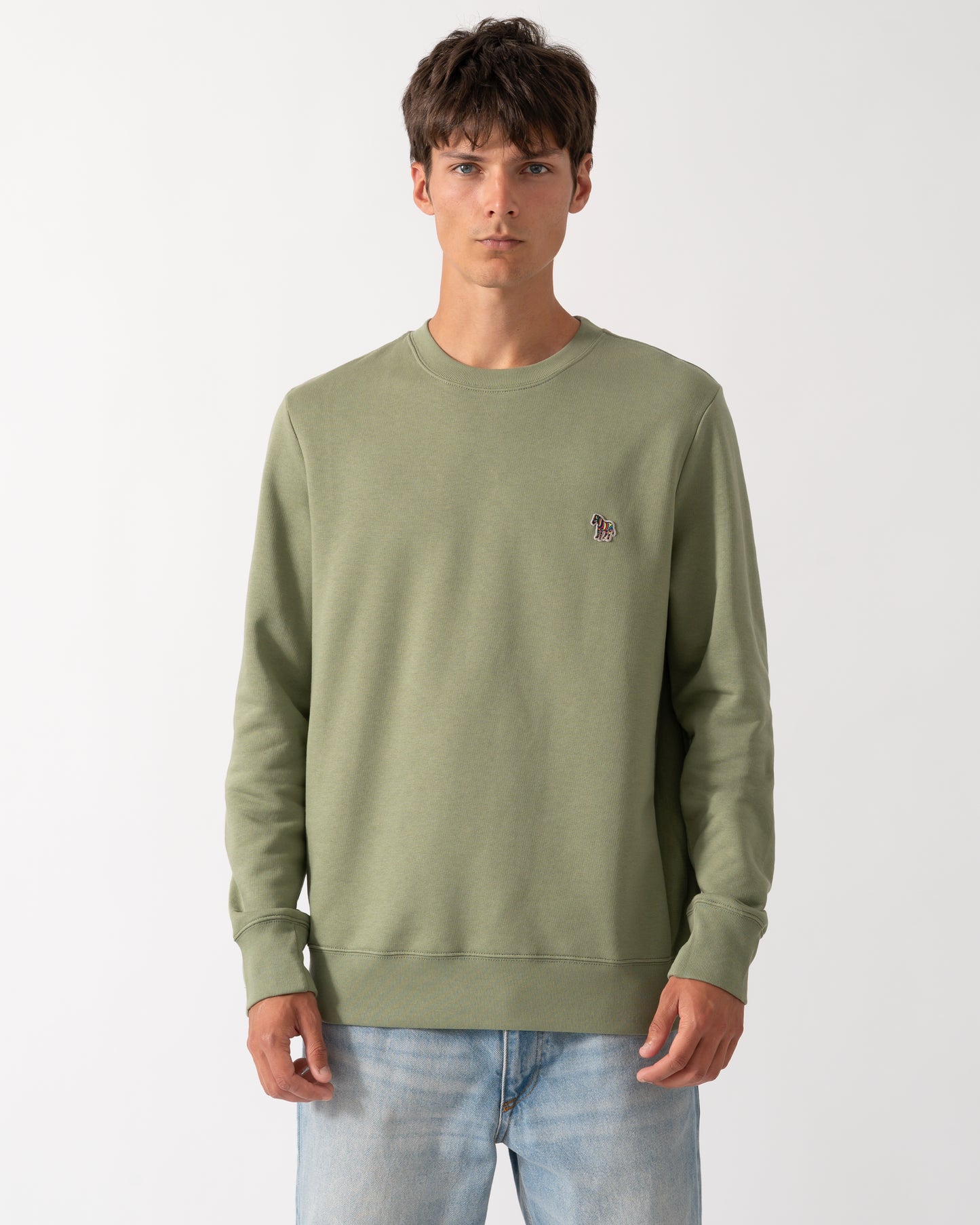 a model wearing a PS Paul Smith Mens Regular Fit Organic Cotton Zebra Logo Sweatshirt in 34C Light Greyish Green
