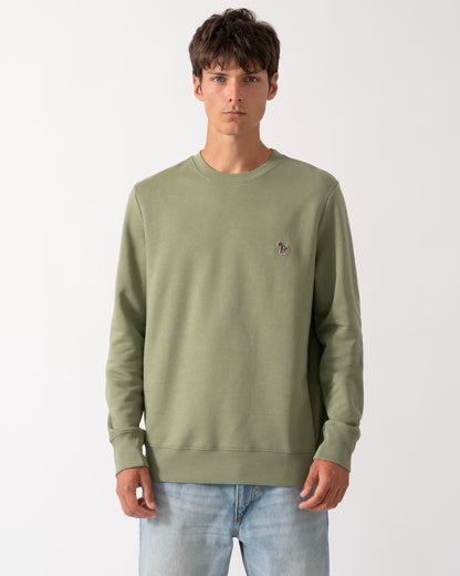 a model wearing a PS Paul Smith Mens Regular Fit Organic Cotton Zebra Logo Sweatshirt in 34C Light Greyish Green