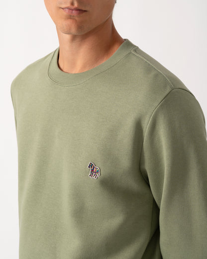 close up of a model wearing a PS Paul Smith Mens Regular Fit Organic Cotton Zebra Logo Sweatshirt in 34C Light Greyish Green