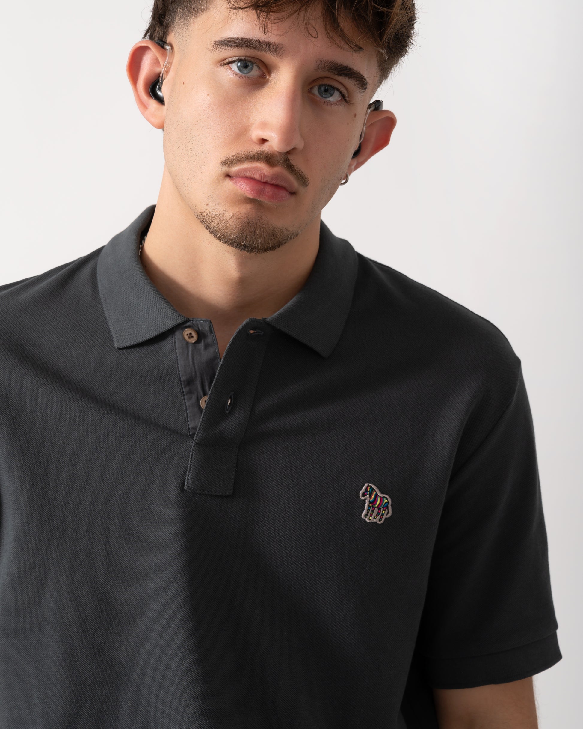 Close up shot of a Model wearing a PS Paul Smith Mens Regular Fit Short Sleeve Zebra Polo Shirt in Grey