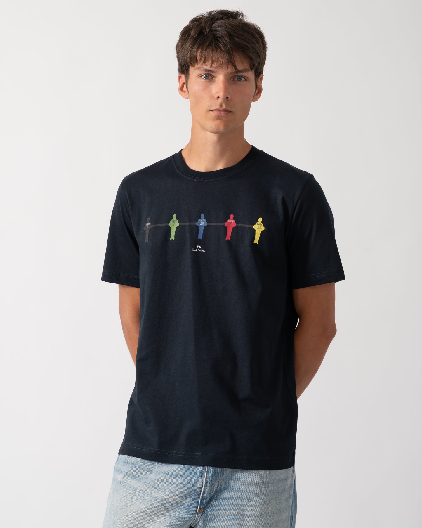 a model wearing a PS Paul Smith Mens Regular Fit Table Football Graphic T-Shirt in 49 Very Dark Navy