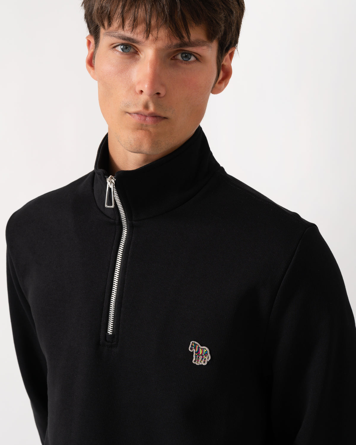 close up of a model wearing a PS Paul Smith Mens Regular Fit Zebra Logo 1/4 Zip Top in 79 Black