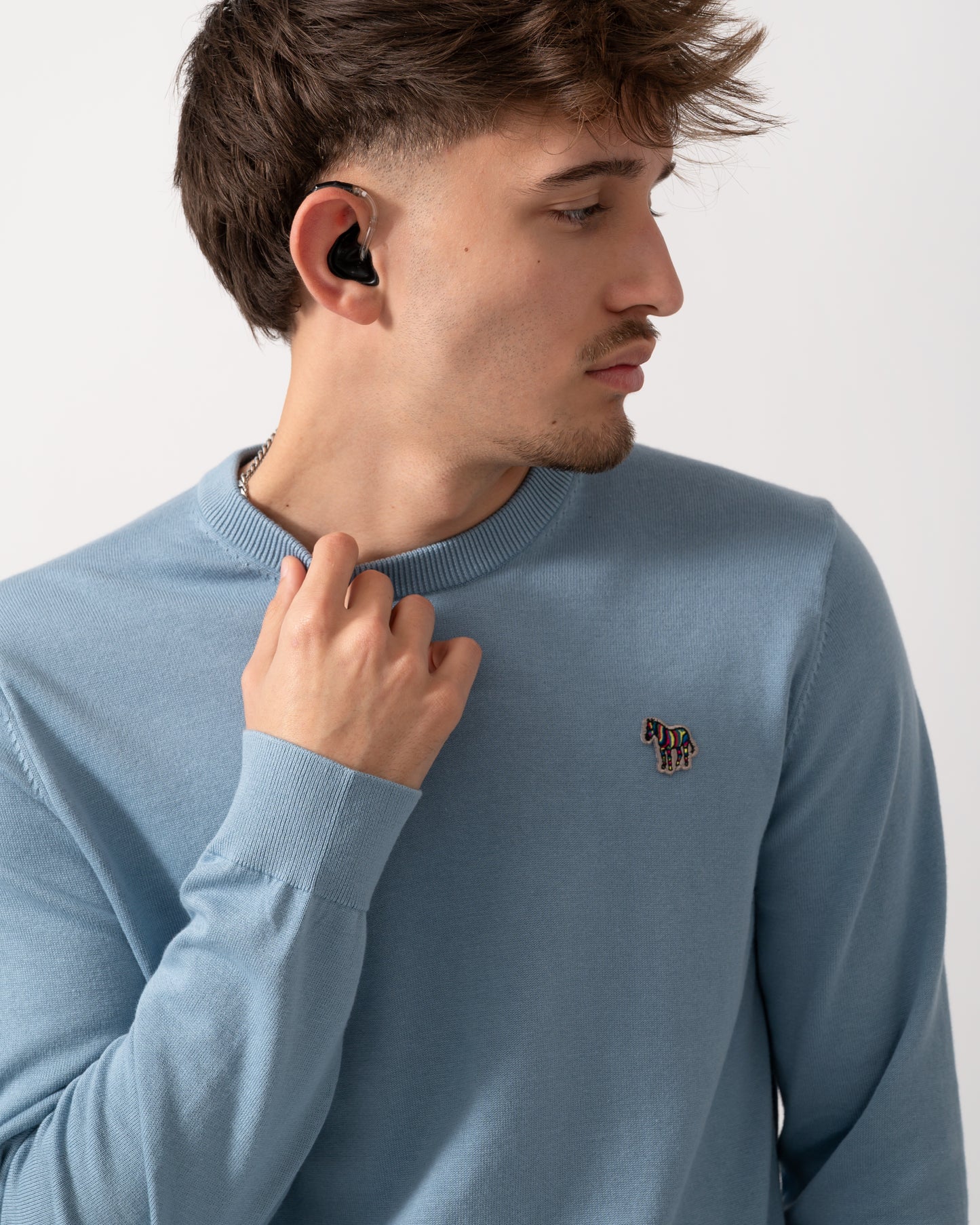 close up of aModel wearing a PS Paul Smith Mens Sweater  Zebra Badge Crew Neck Sweatshirt in Blue