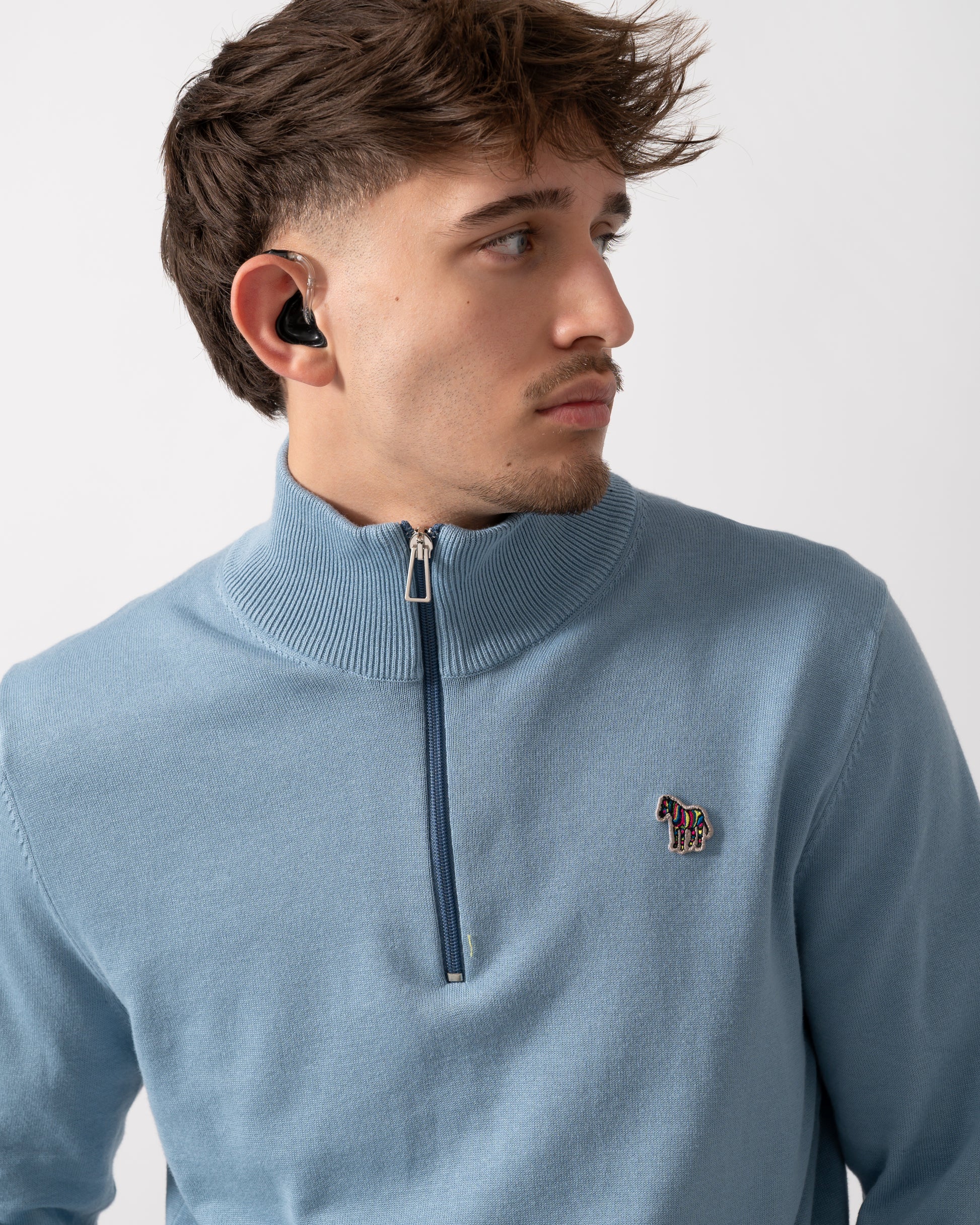 Detail of a Model wearing a PS Paul Smith Mens Sweater Zip Neck Zebera Badge in Blue
