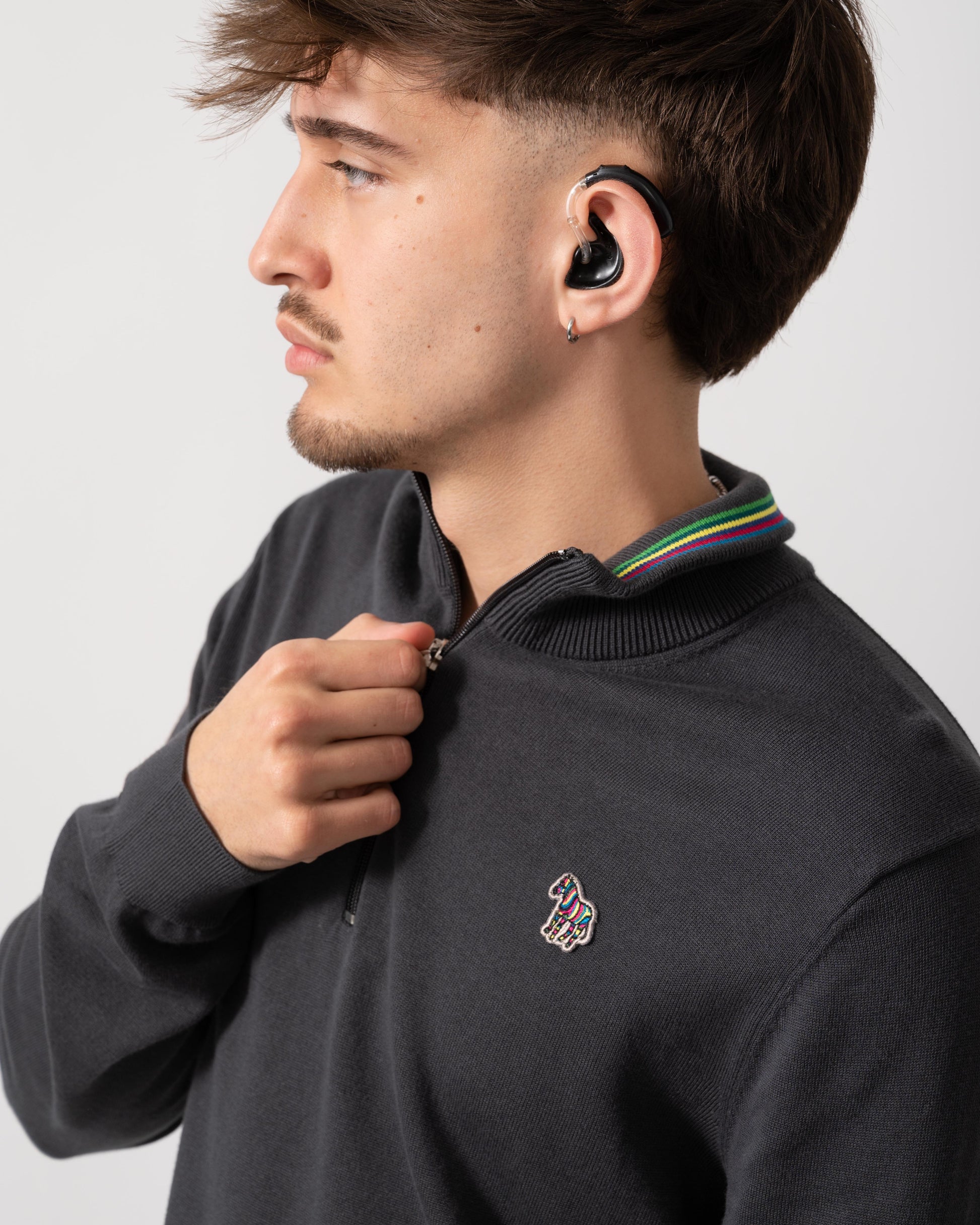 Detail shot of a Model wearing a PS Paul Smith Mens Sweater Zip Neck Zebera Badge in Grey